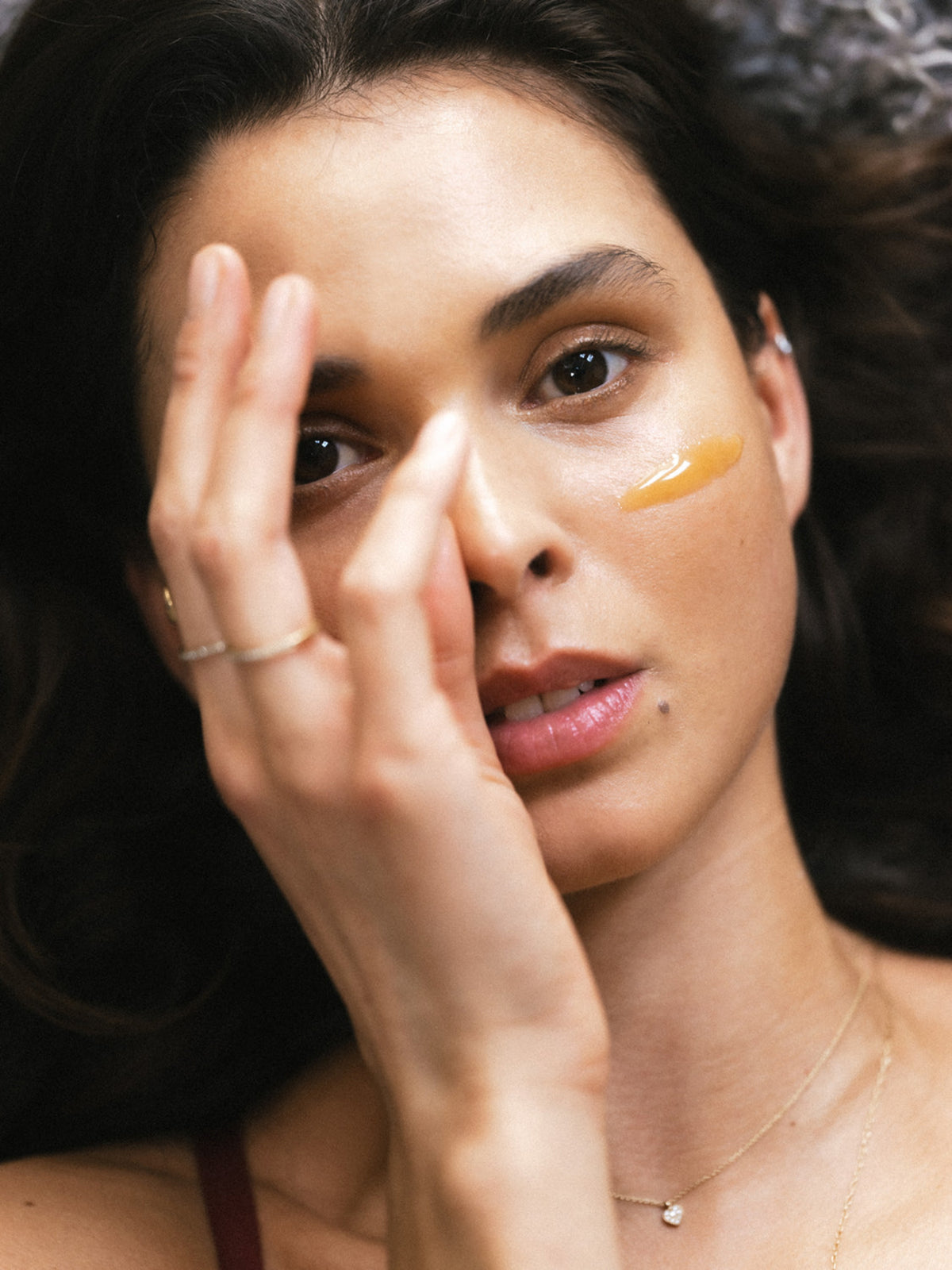 Model applying Activist Manuka Honey 850+ MGO to the skin