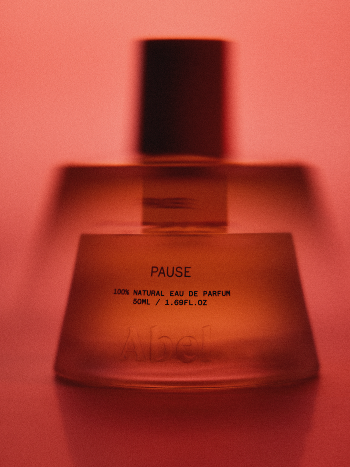 ABEL Pause 50 ml 100% Natural Eau de Parfum bottle in warm red light