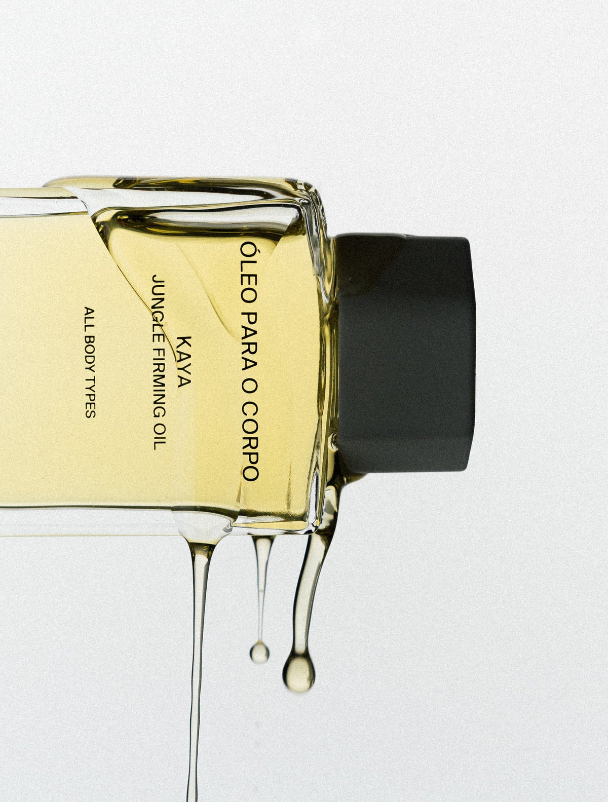 Costa Brazil Kaya Jungle Firming Oil bottle with oil dripping on a white background