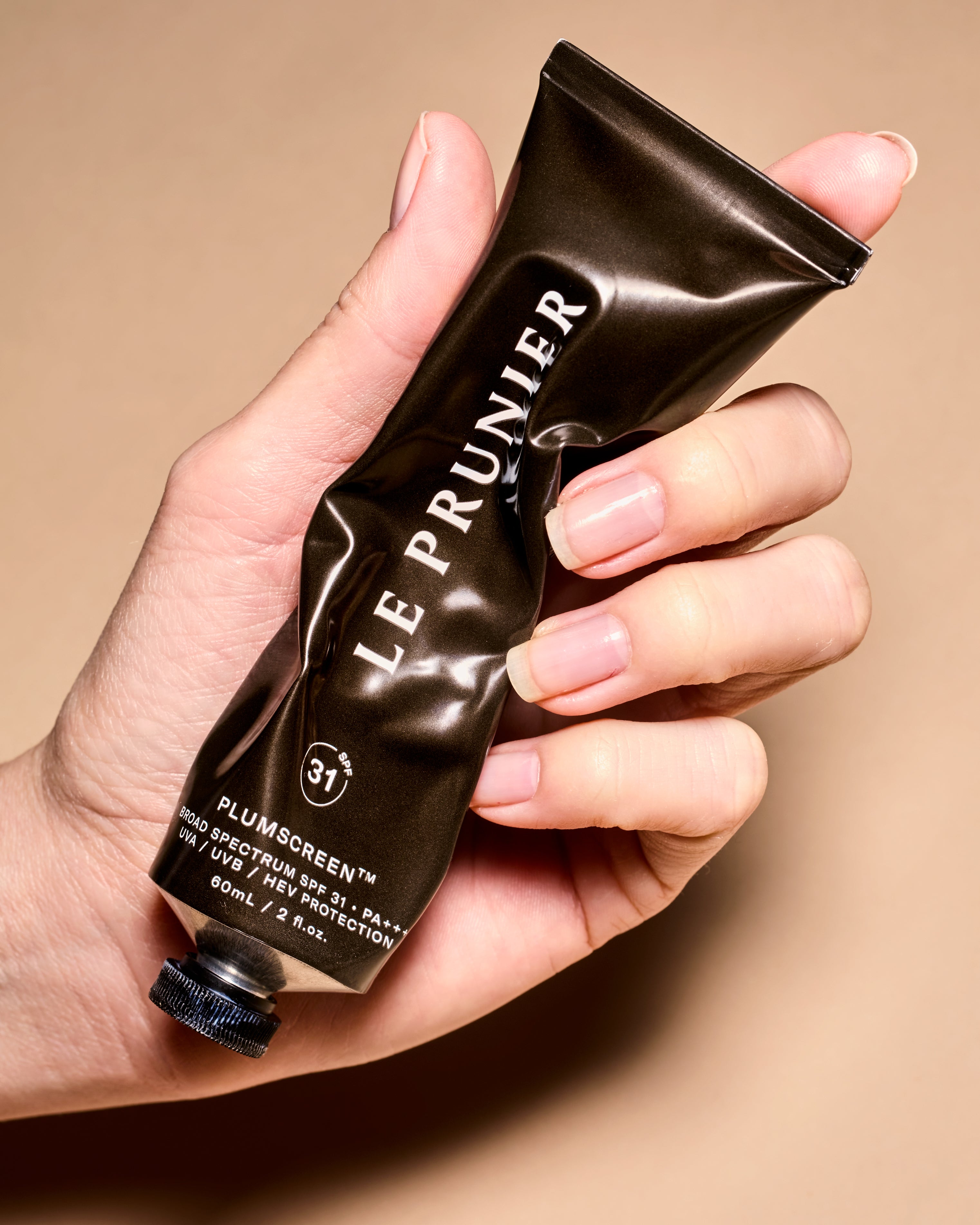 Le Prunier Plum Beauty Oil product shot hand