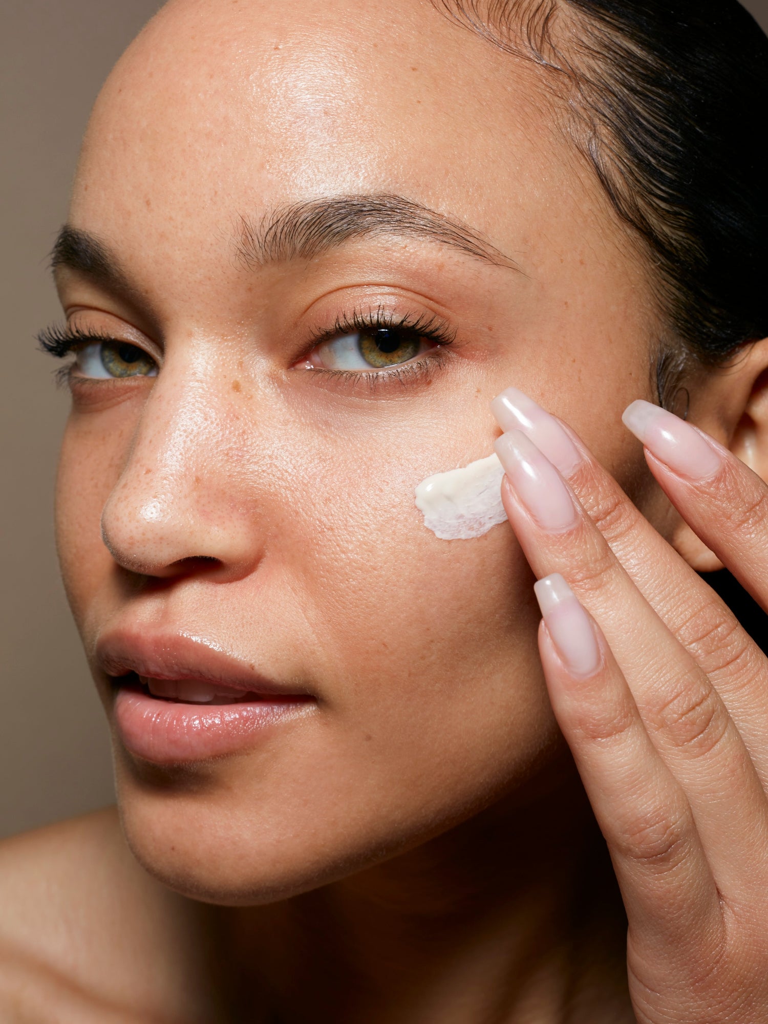 Applying Le Prunier Plumscreen SPF 31 sunscreen to the face for daily broad-spectrum UV protection