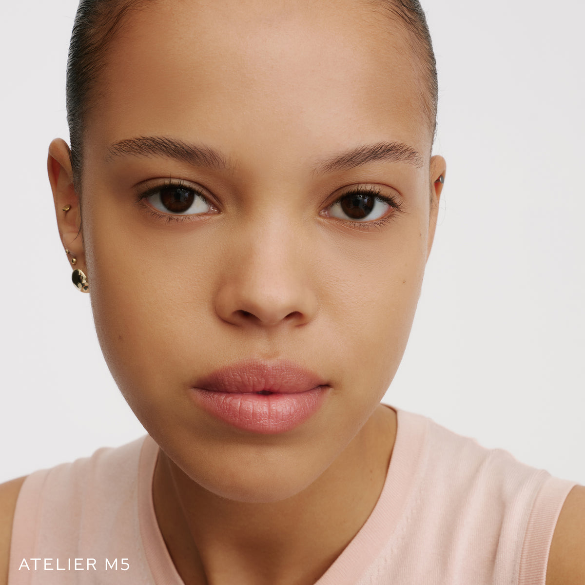 The Face of a Model wearing the WESTMAN ATELIER Suprême Bio-Complex Liquid Foundation in the shade M5