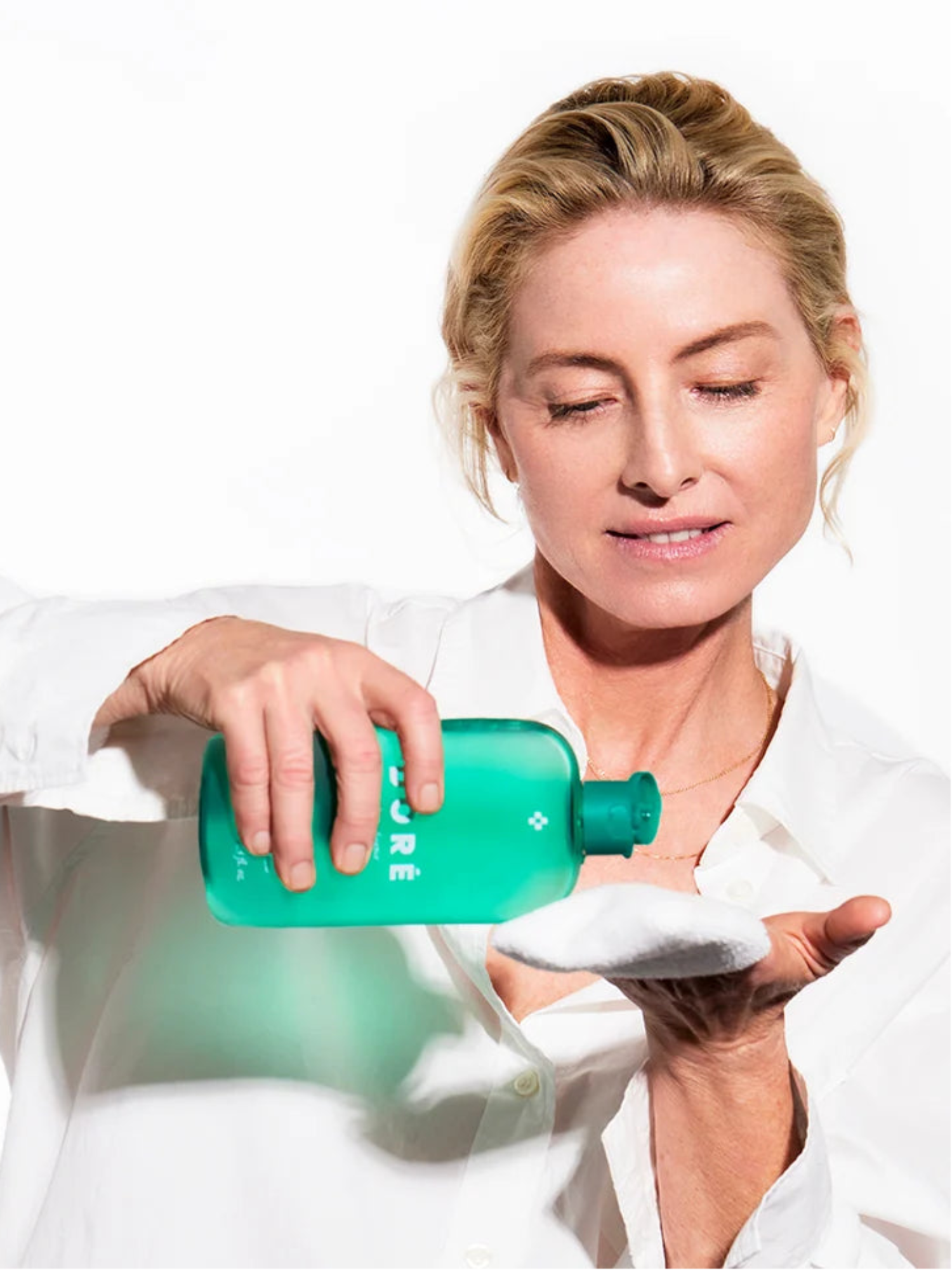 Woman applying DORÉ La Micellaire Botanical Cleansing Water with cotton pad