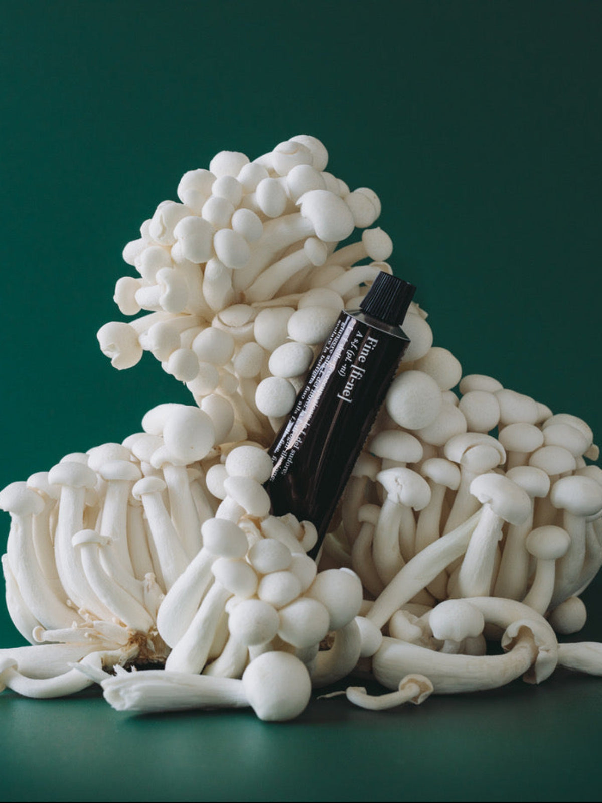 FINE Deodorant Vetiver Geranium displayed among white mushrooms on a green background