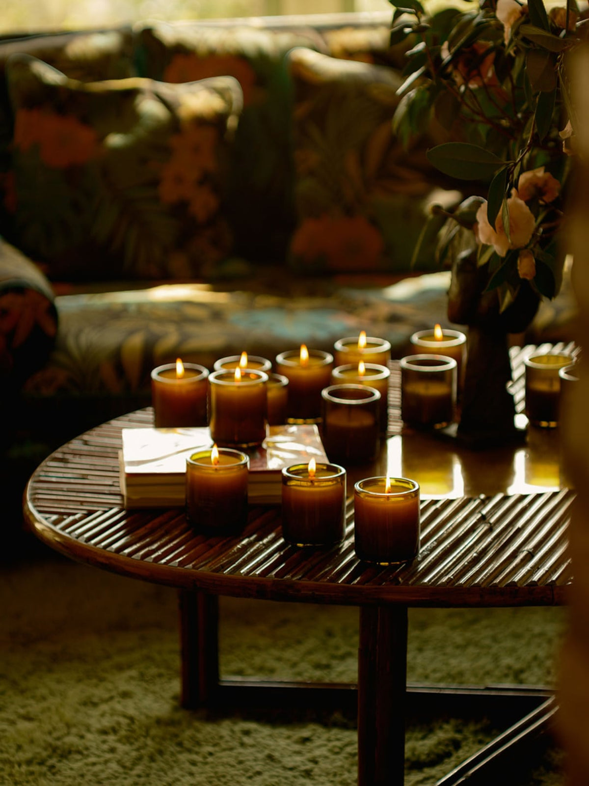 Lit Flamingo Estate Climbing Tuscan Rosemary candles displayed alongside green gift boxes