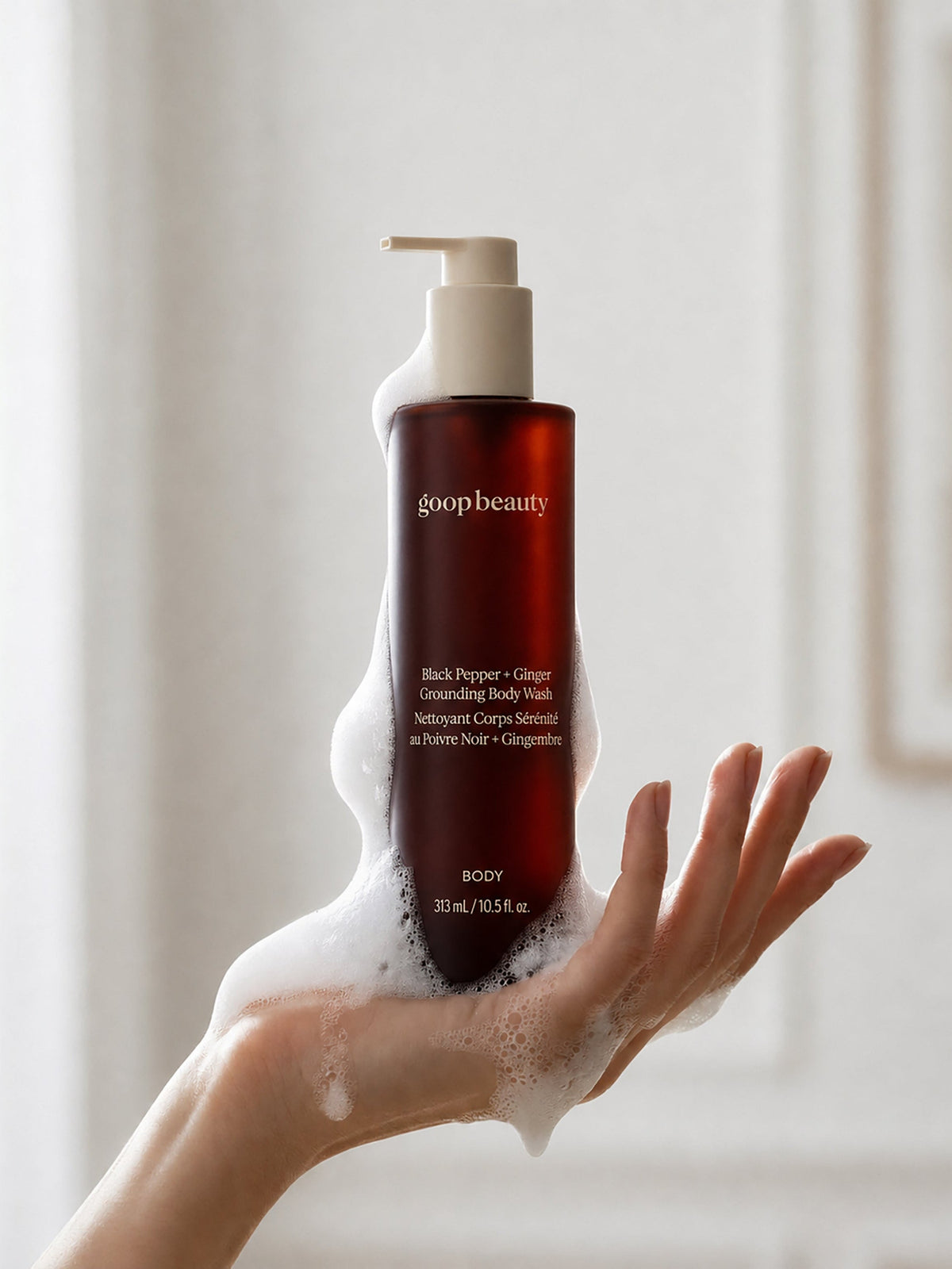 goop beauty Black Pepper + Ginger Grounding Body Wash with foam on hand