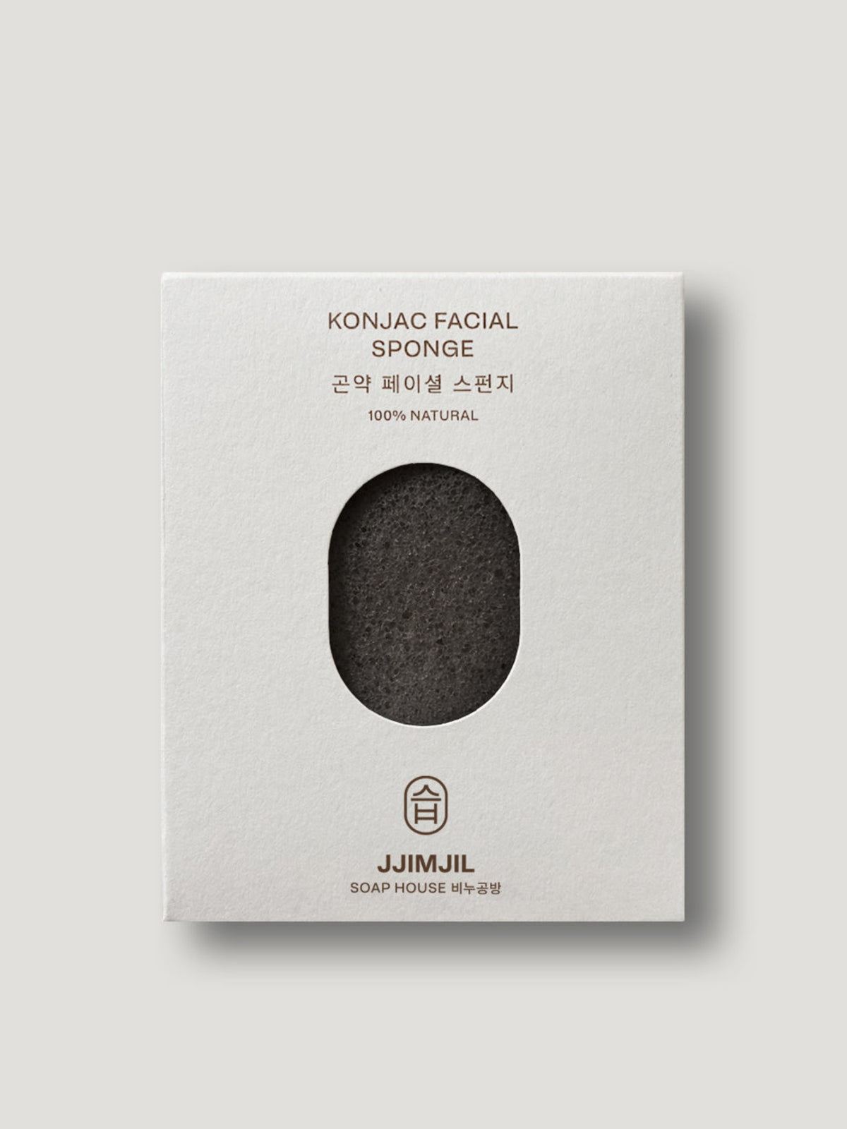 Jjimjil Konjac Facial Sponge in charcoal displayed in its white packaging, featuring a natural black sponge and minimalist design