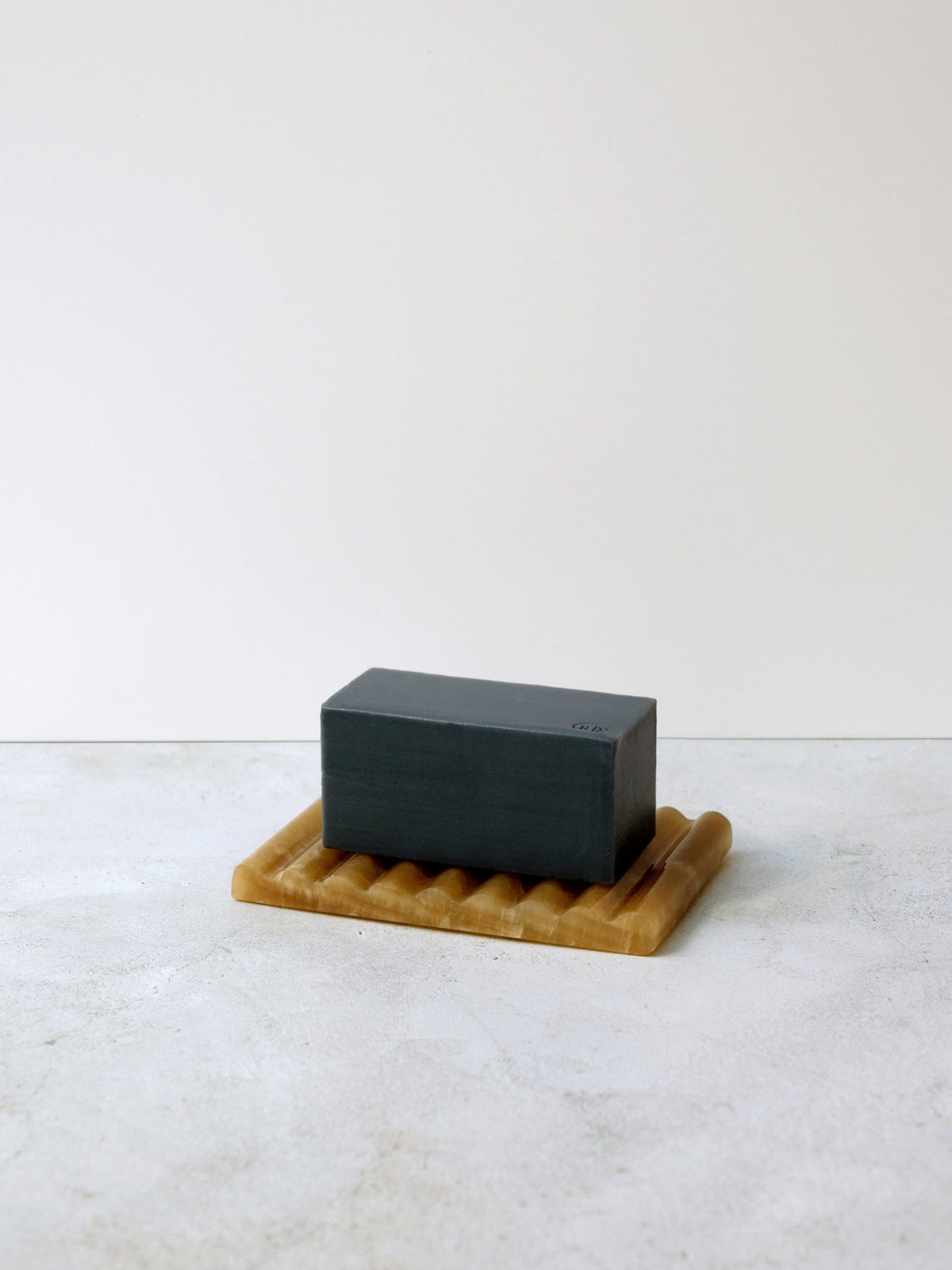 JJIMJIL Shaman Charcoal Soap bar displayed on a natural textured surface