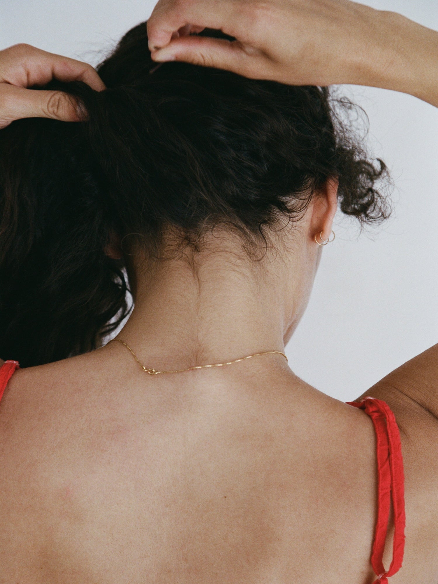 Model tying up hair inspired by ABEL Nurture Eau de Parfum