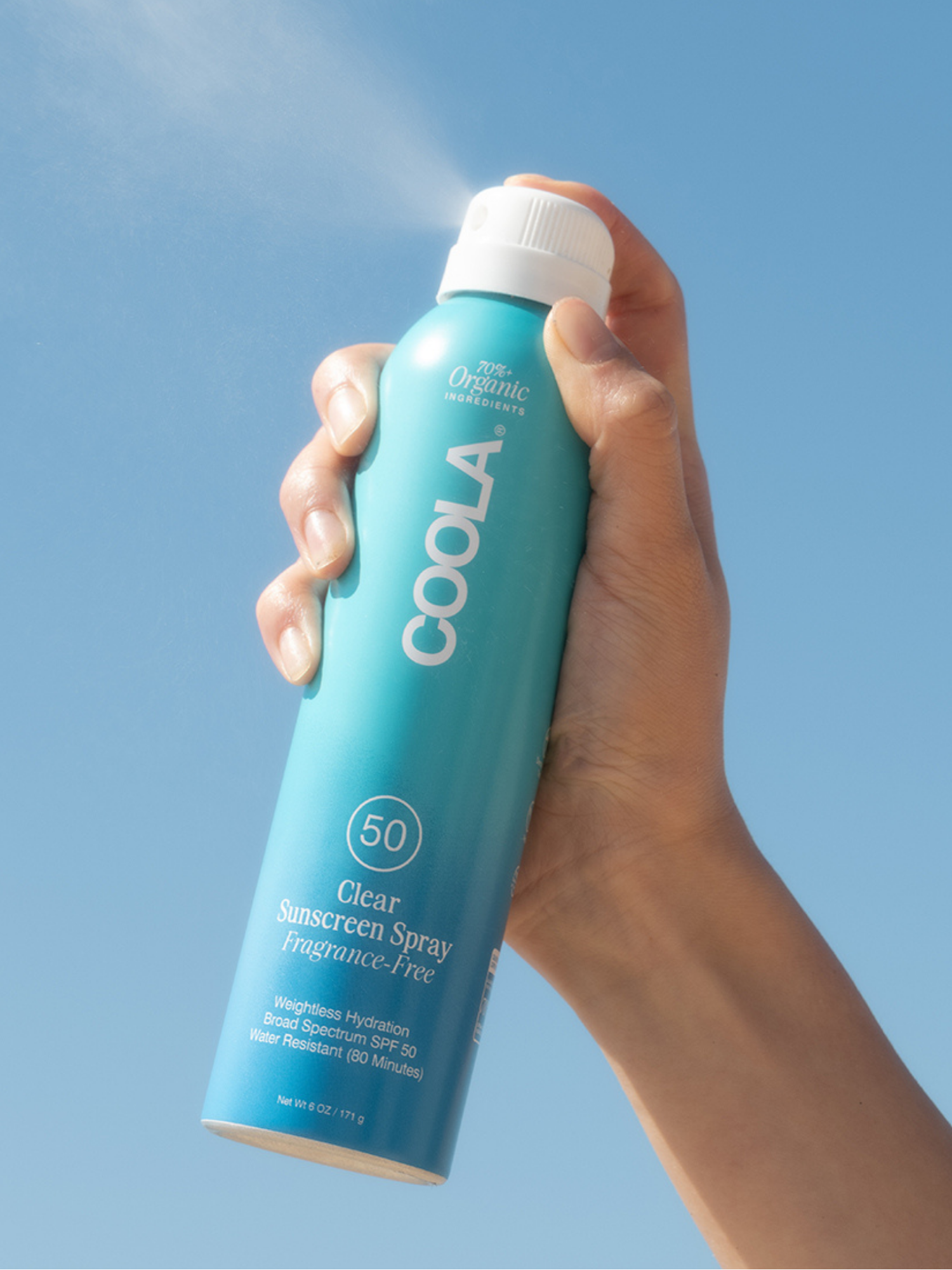 COOLA Clear Sunscreen Spray SPF 50 Fragrance-Free being sprayed into the air