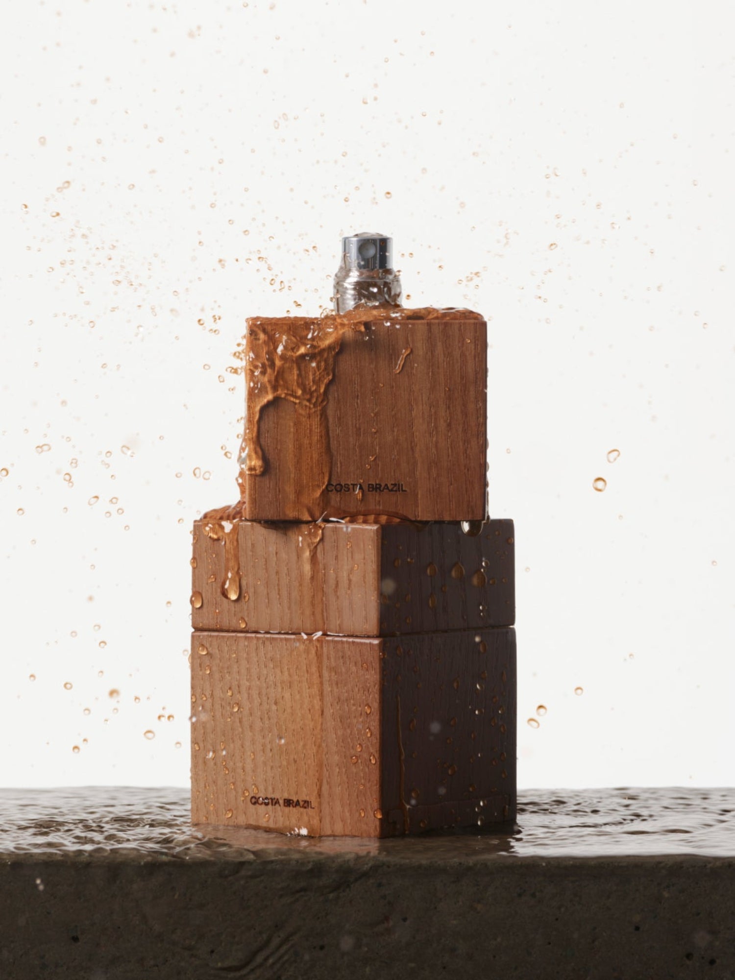 COSTA BRAZIL Aroma Eau de Parfum – wooden fragrance bottle with water droplets on a wet surface