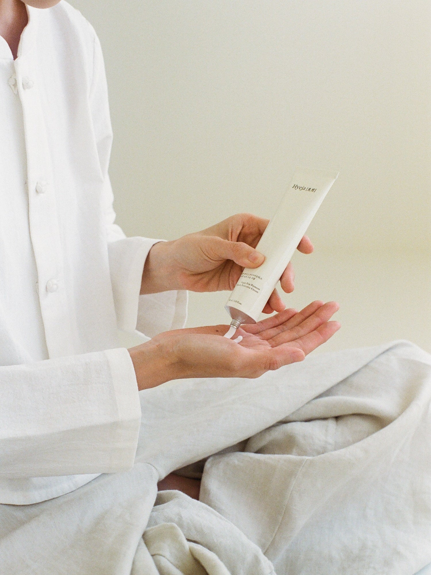 HYEJA Yuja Rice Ferment Cream applied to hands from skincare tube