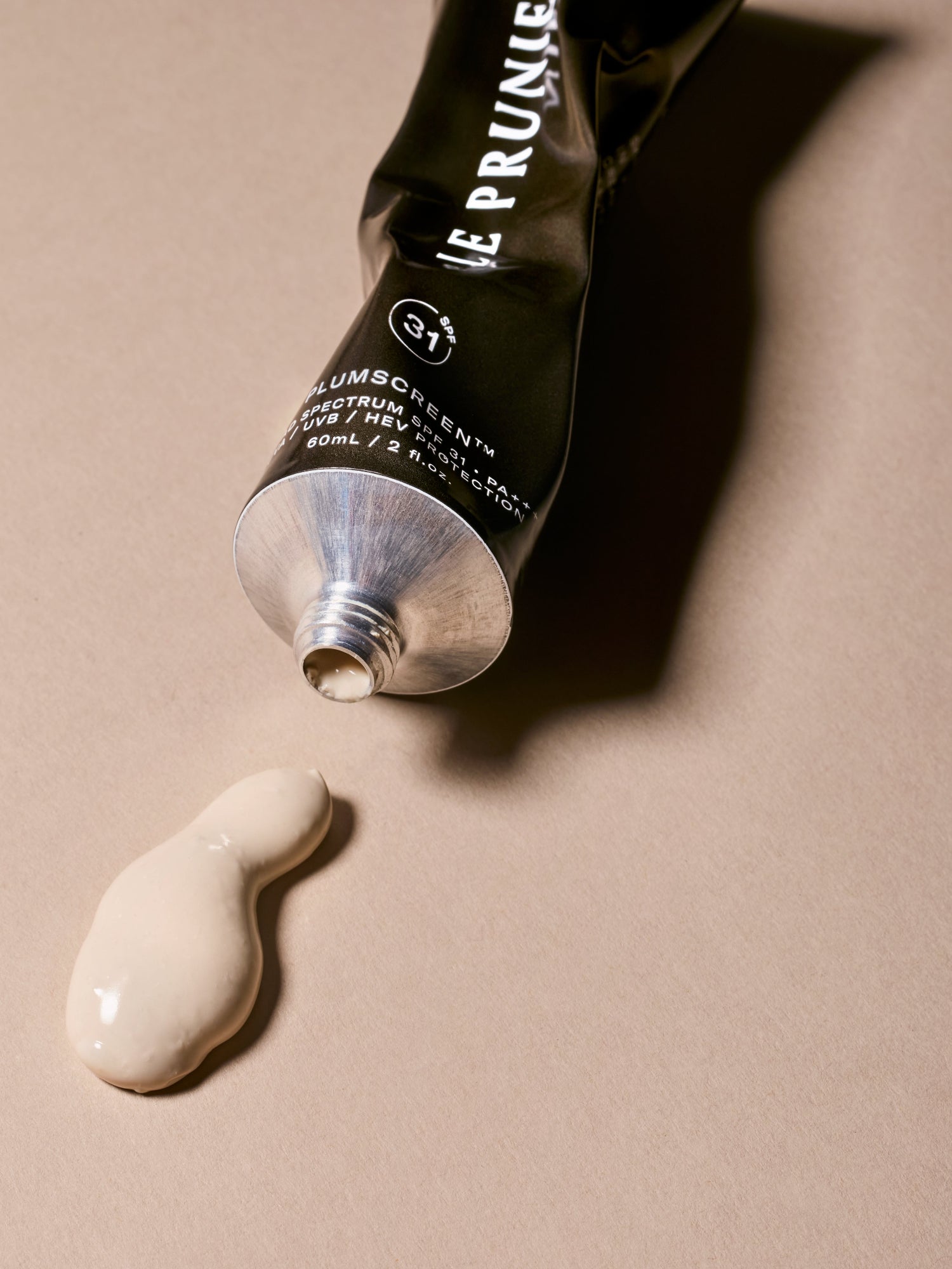 Le Prunier Plumscreen SPF 31 sunscreen cream dispensed from aluminum tube with product texture