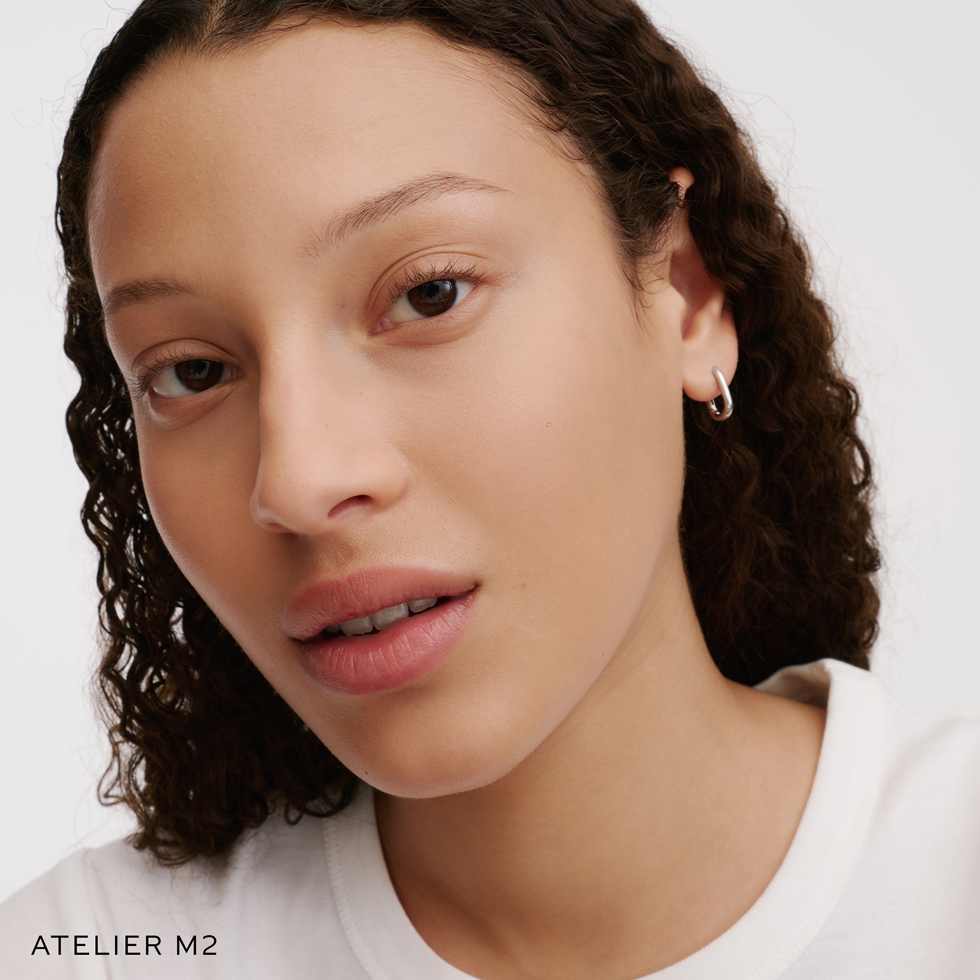 The Face of a Model wearing the WESTMAN ATELIER Suprême Bio-Complex Liquid Foundation in the shade  M2