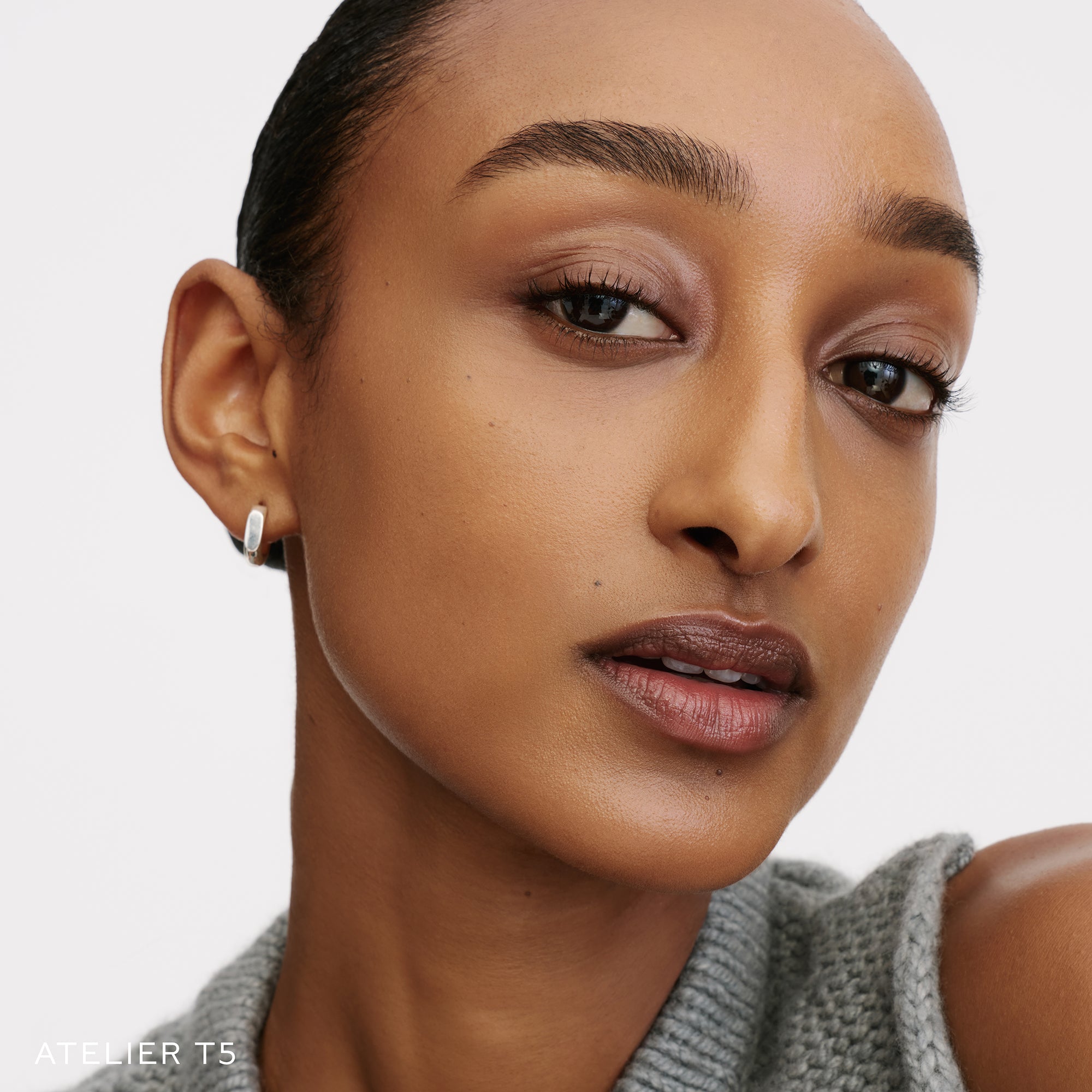 The Face of a Model wearing the WESTMAN ATELIER Suprême Bio-Complex Liquid Foundation in the shade T5