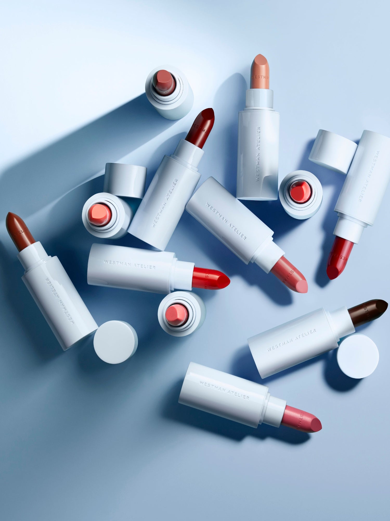 Westman Atelier Lip Suede Matte Lipstick collection in multiple shades with light blue packaging.