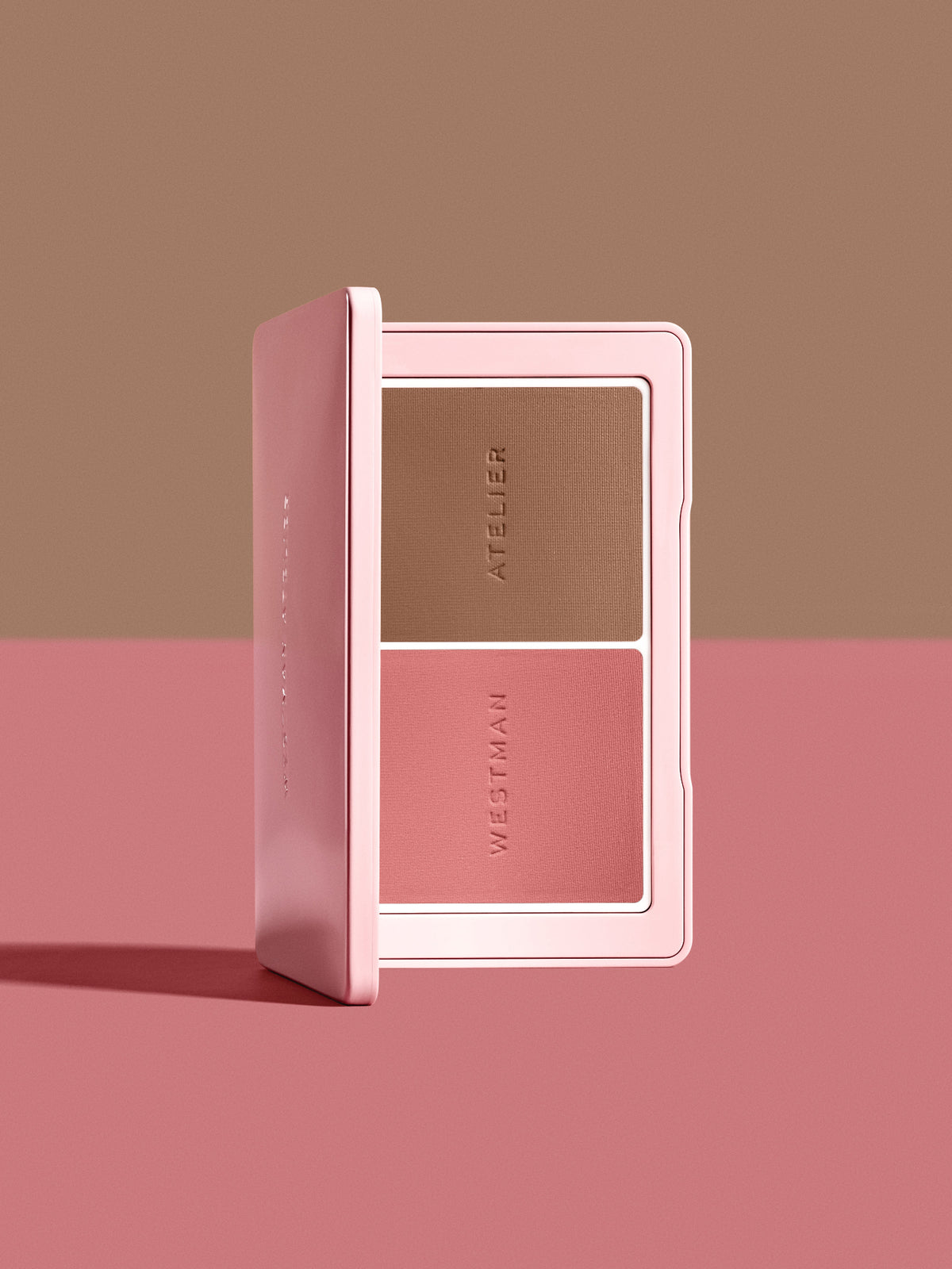 Open Westman Atelier Powder Blush & Contour Duo in shades Petal and Biscuit on a pink and brown background.