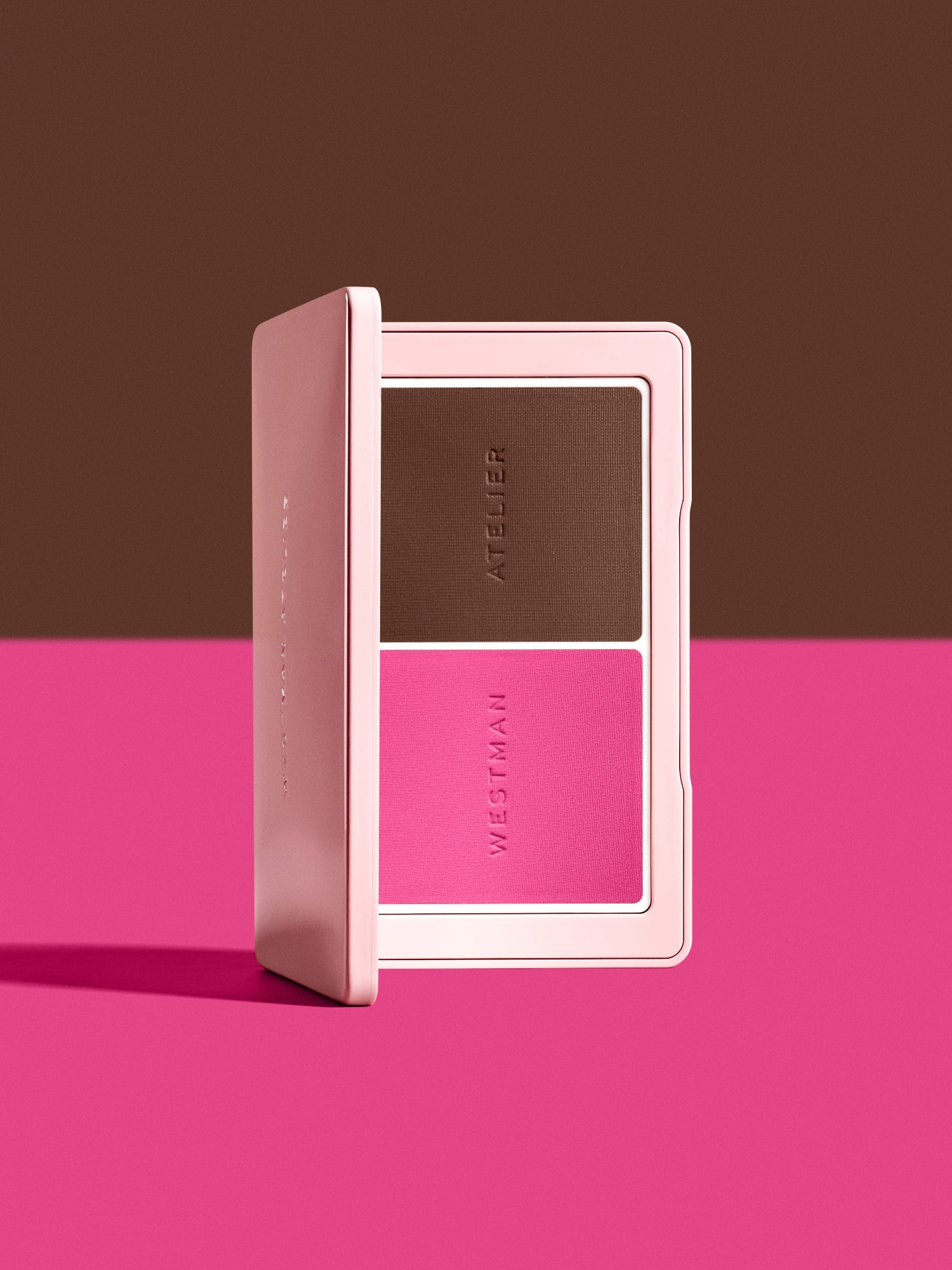 Open Westman Atelier Powder Blush & Contour Duo in shades Poppet and Ganache on a pink background.