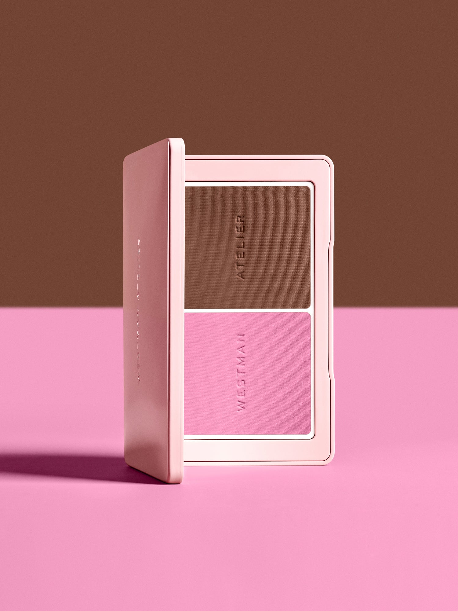 Open Westman Atelier Powder Blush & Contour Duo in shades Tulle and Truffle on a pink and brown background.