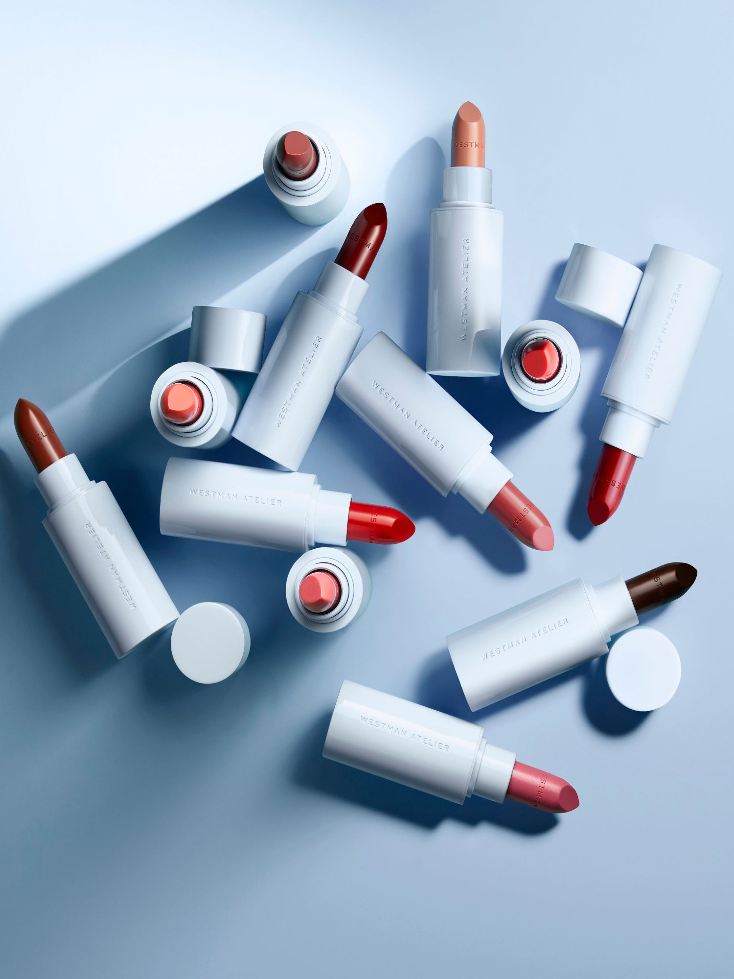 Westman Atelier Lip Suede Matte Lipstick collection in multiple shades with light blue packaging.