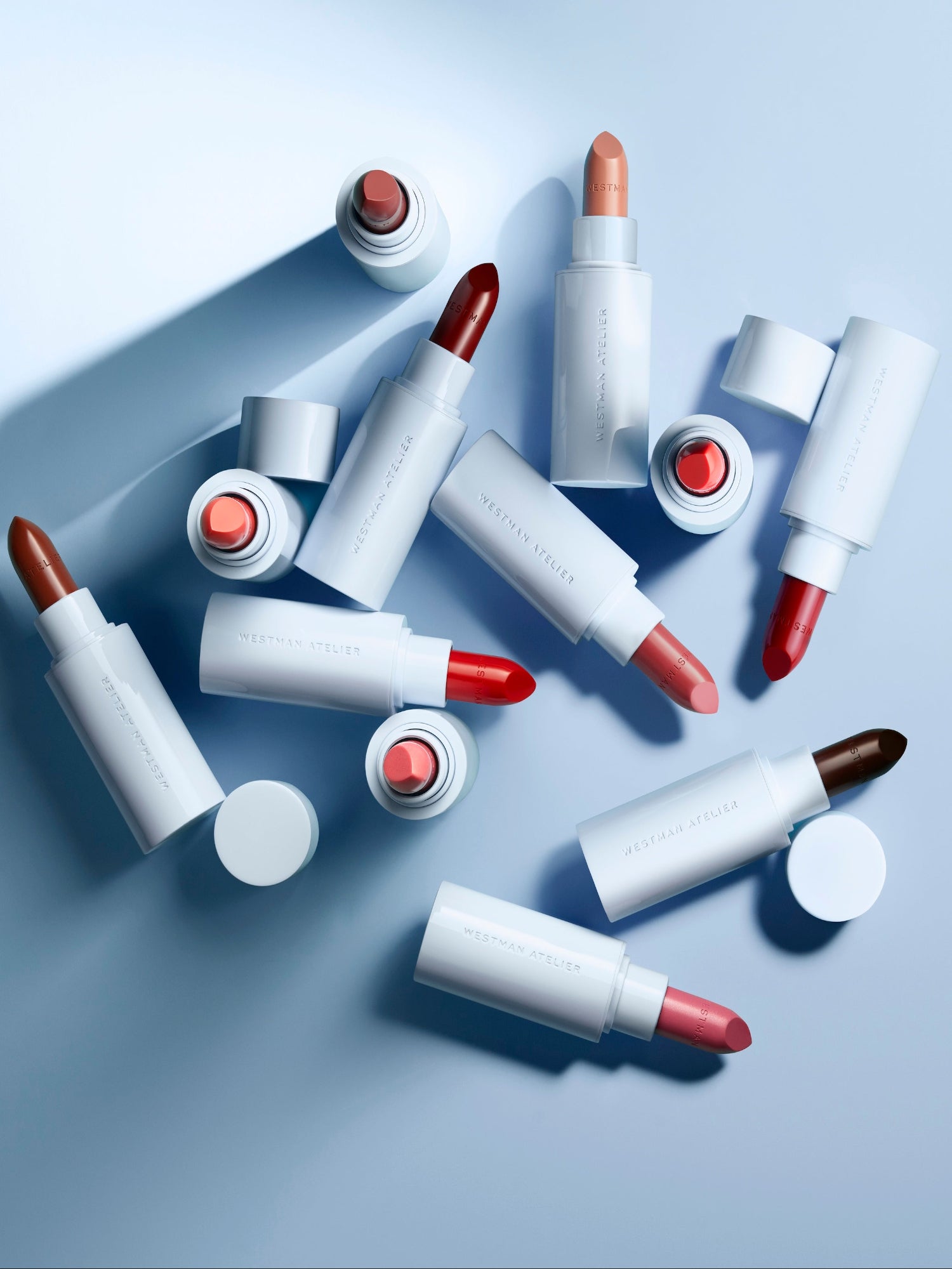 Westman Atelier Lip Suede Matte Lipstick collection in multiple shades with light blue packaging.