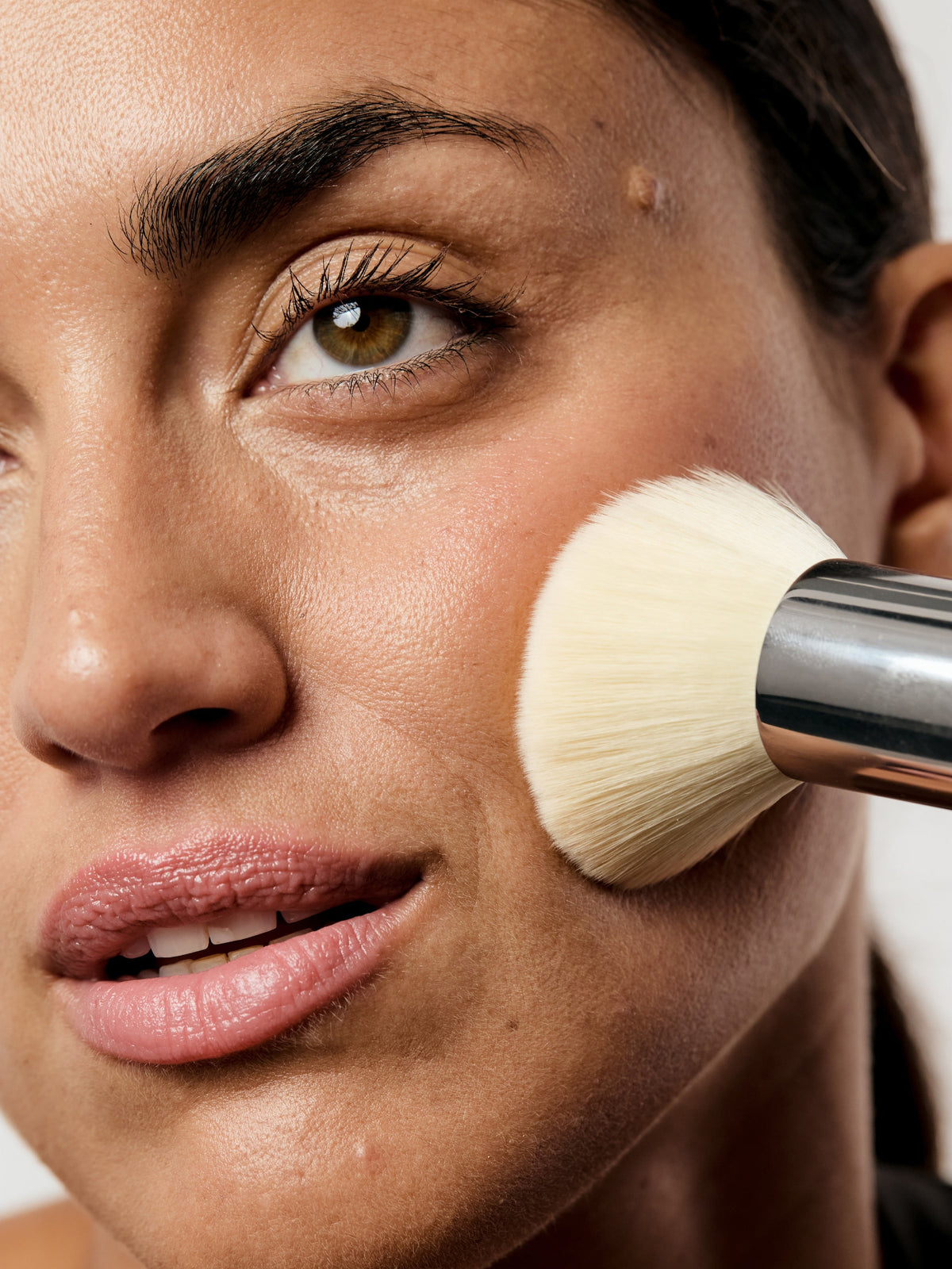 AIME Skincare Powder Foundation SPF 30 with makeup brush on model