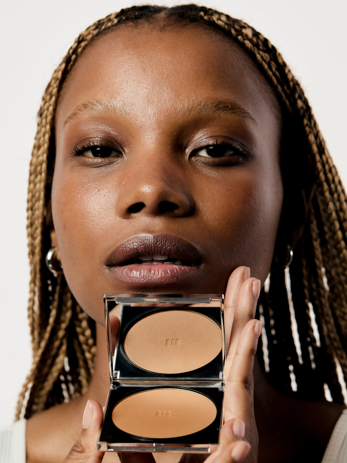 AIME Skincare Powder Foundation SPF 30 held by model