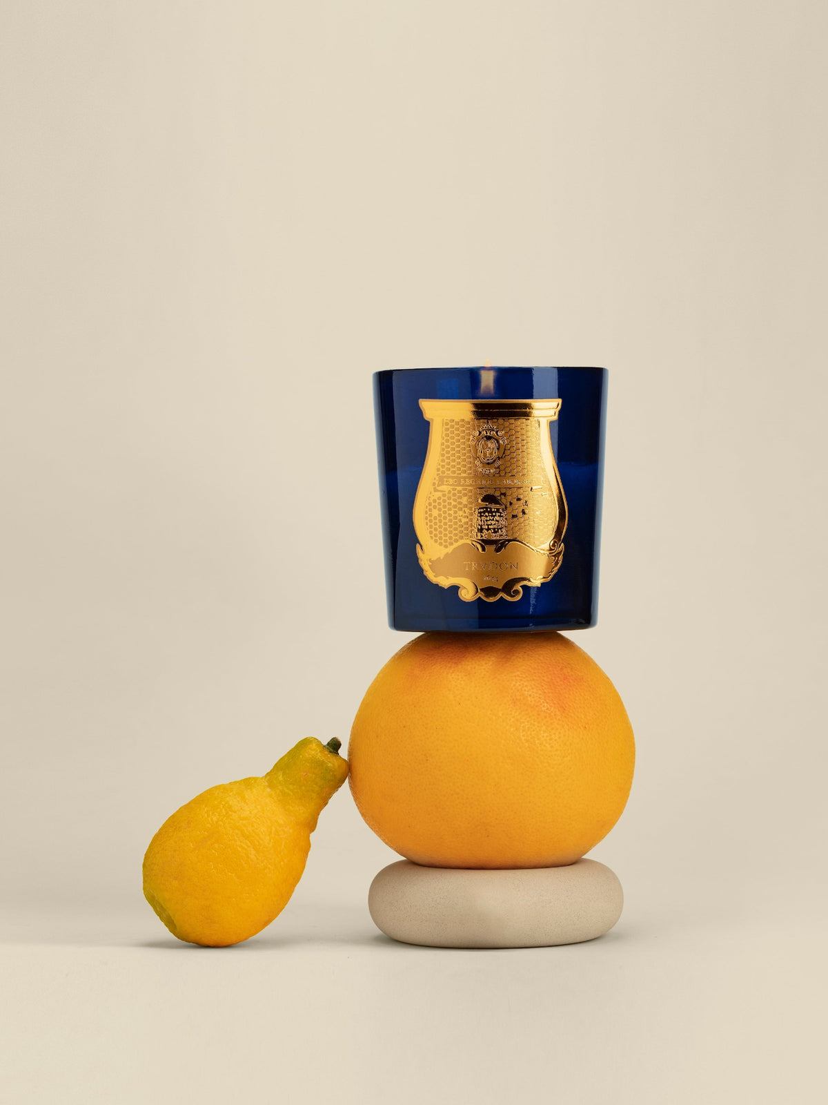 Cire Trudon Belles Matières scented candle styled with orange and lemon on a neutral background