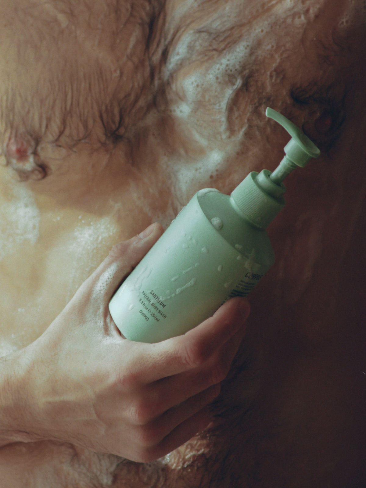Corpus Body Wash bottle in shower with hands