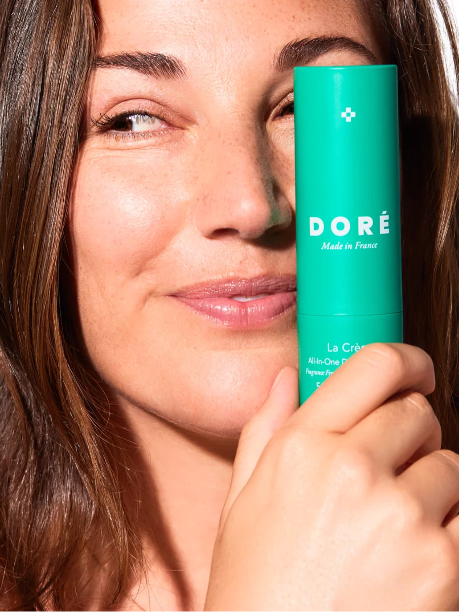 Model holding DORÉ La Crème All-In-One Daily Moisturizer 50 ml