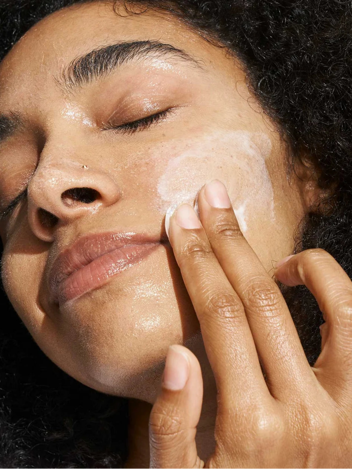 Woman applying DORÉ Le Cleanser Gel to Milk Cleanser to the face