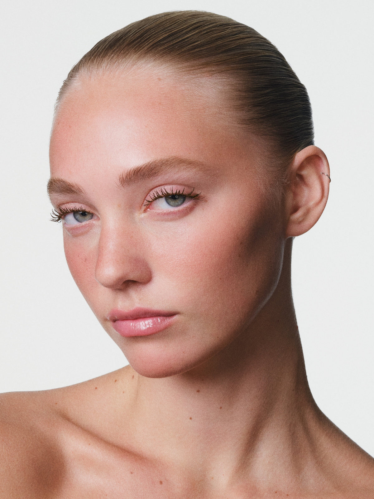 Model wearing Fara Homidi Pool Slick Lash Lacquer mascara absolu black