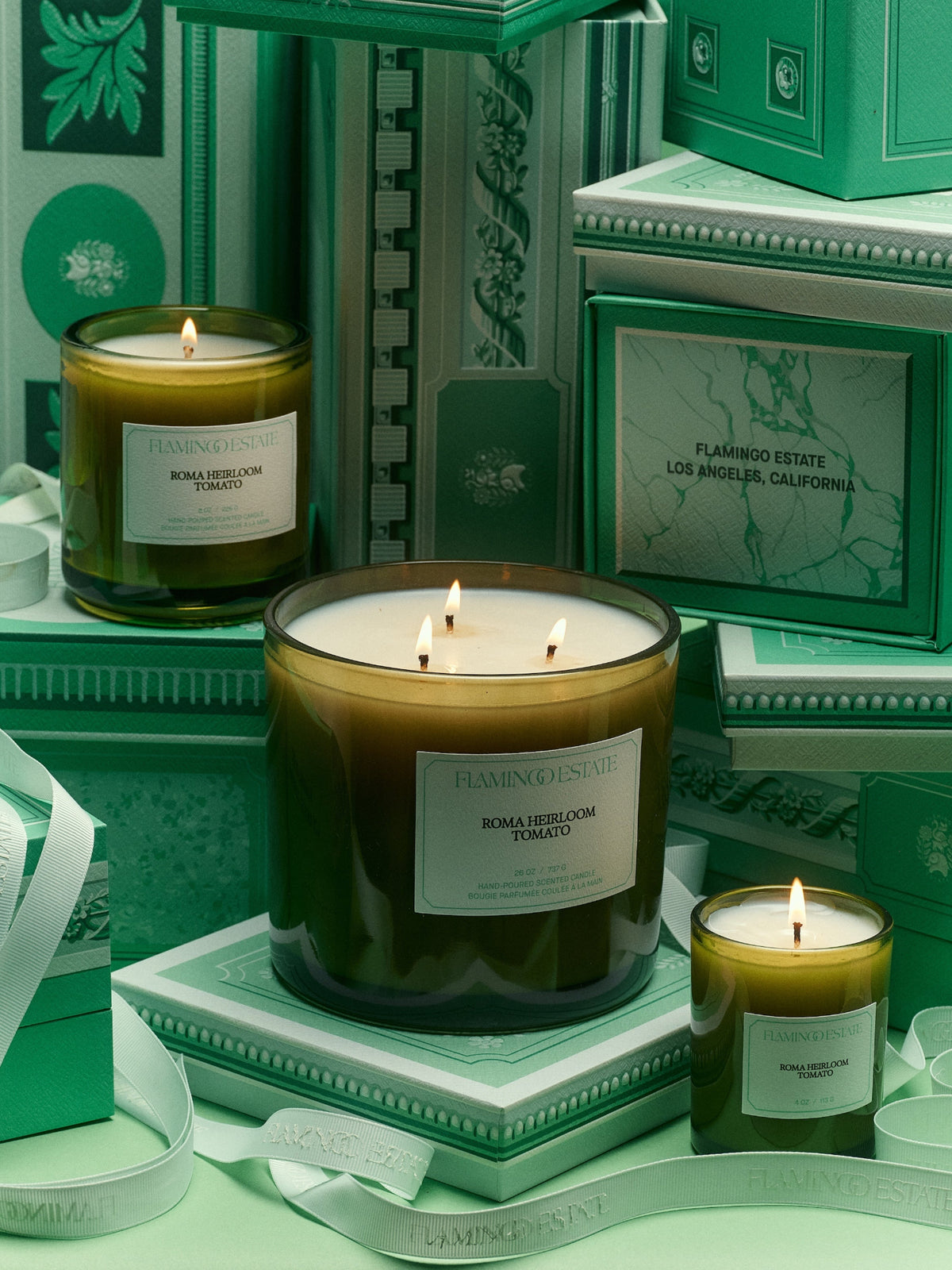 Flamingo Estate Roma Heirloom Tomato candles in different sizes displayed with green gift boxes