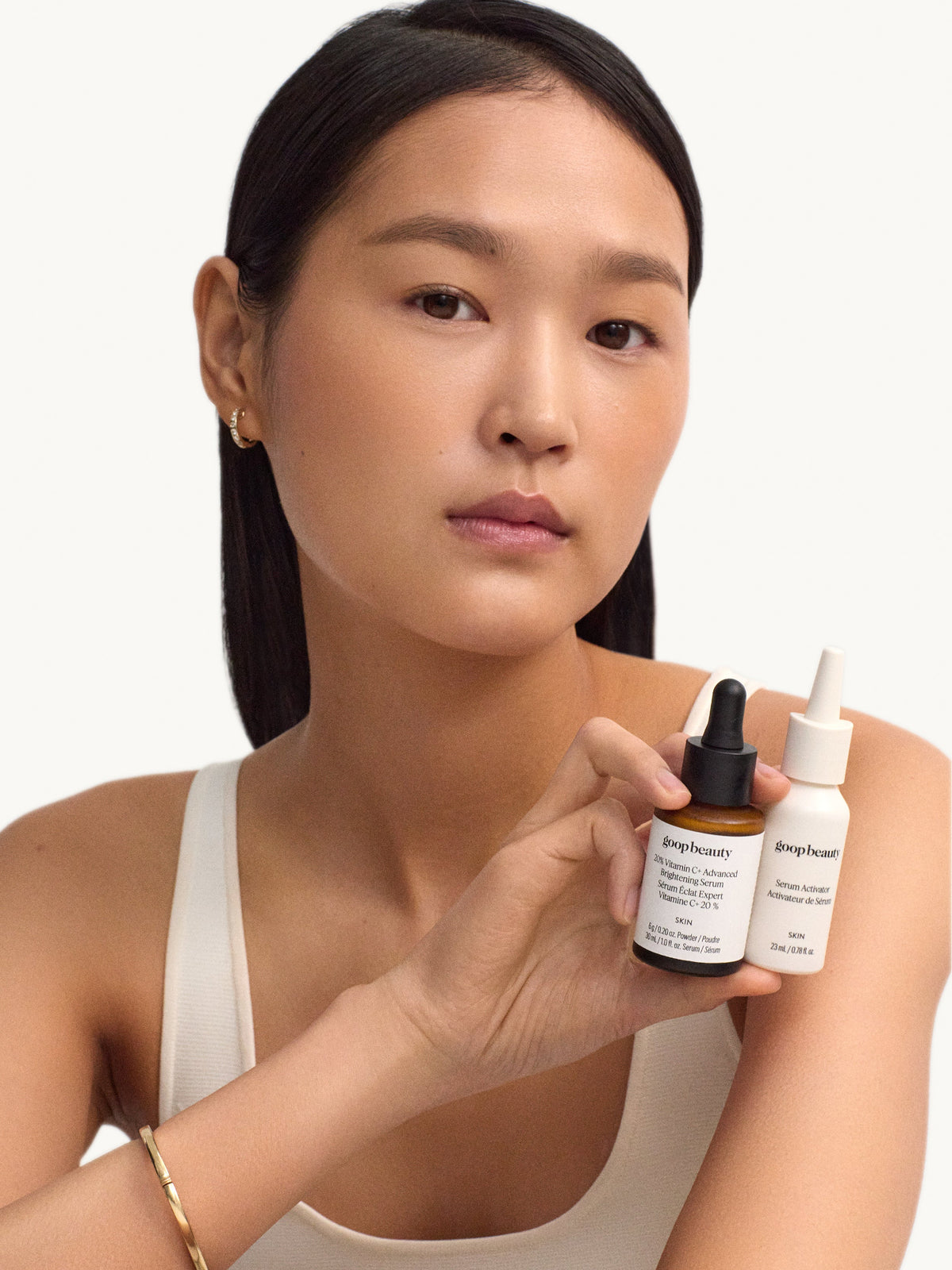 Model holding goop beauty 20% Vitamin C + Hyaluronic Acid Glow Serum