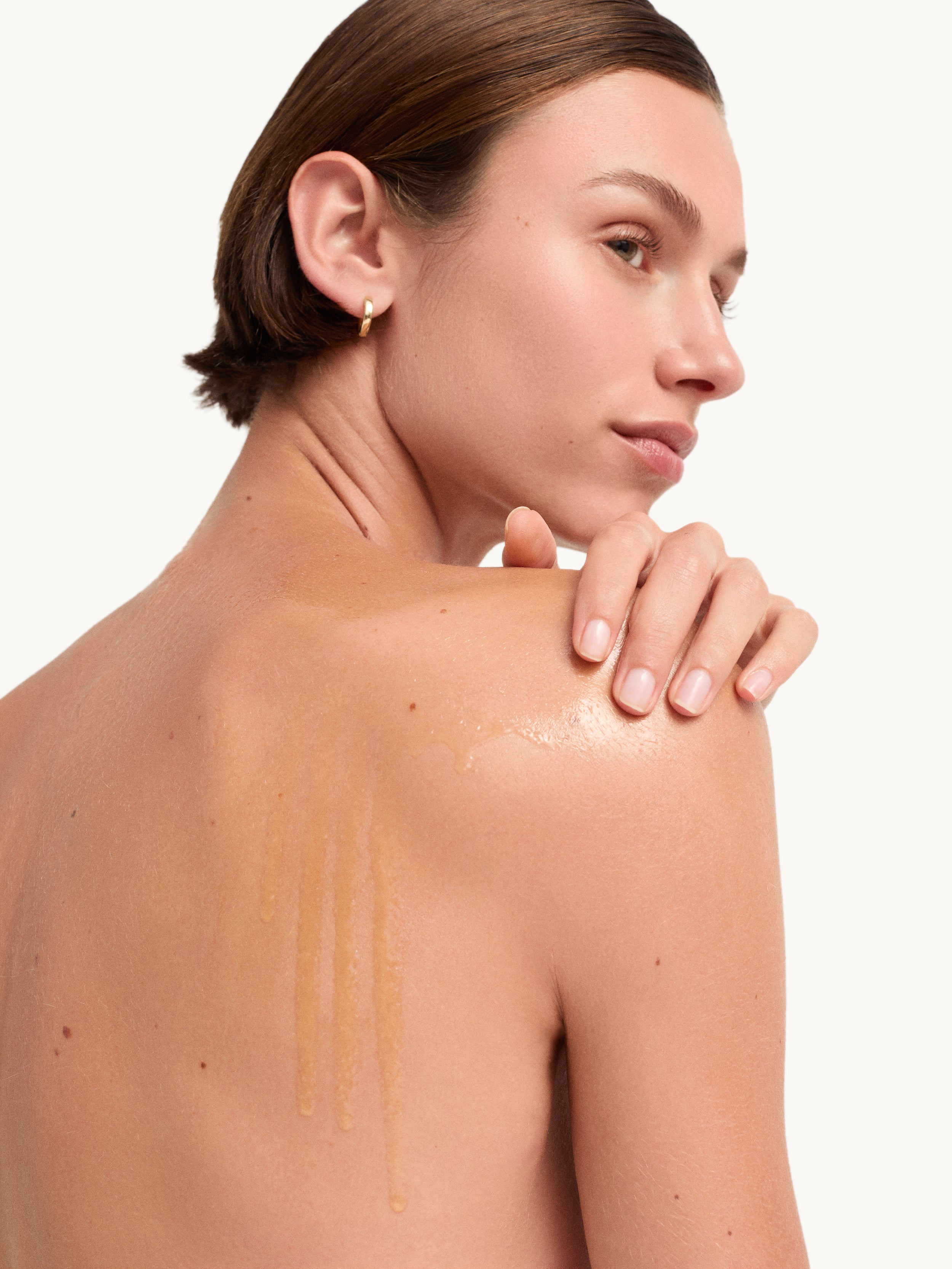 Model with goop beauty Afterglow Body Oil applied to skin