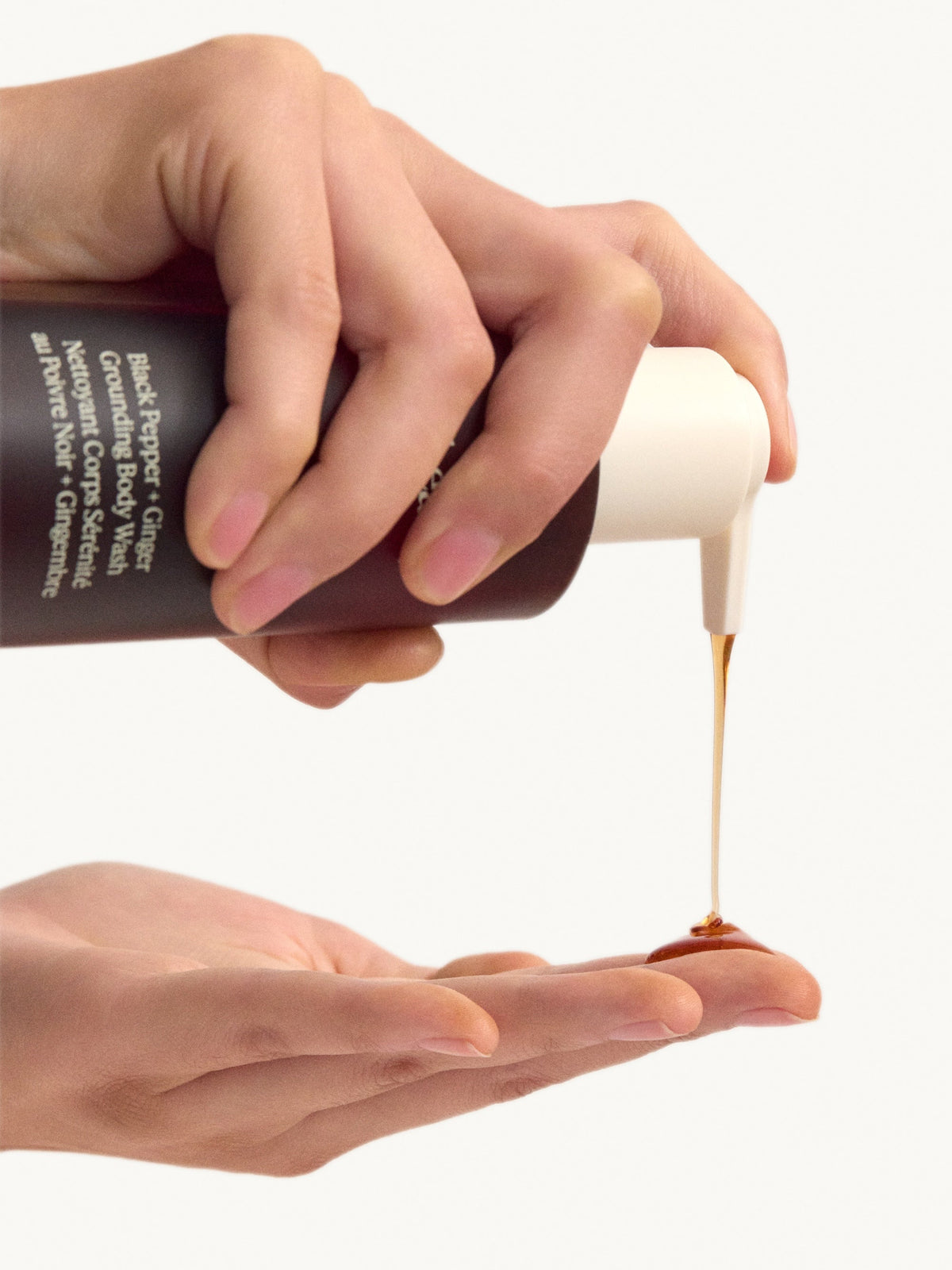 goop beauty Black Pepper + Ginger Grounding Body Wash dispensed onto hand