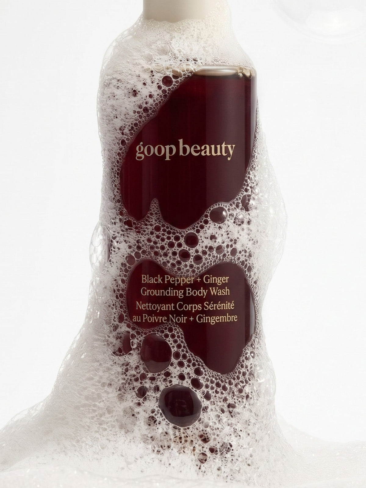 goop beauty Black Pepper + Ginger Grounding Body Wash surrounded by foam