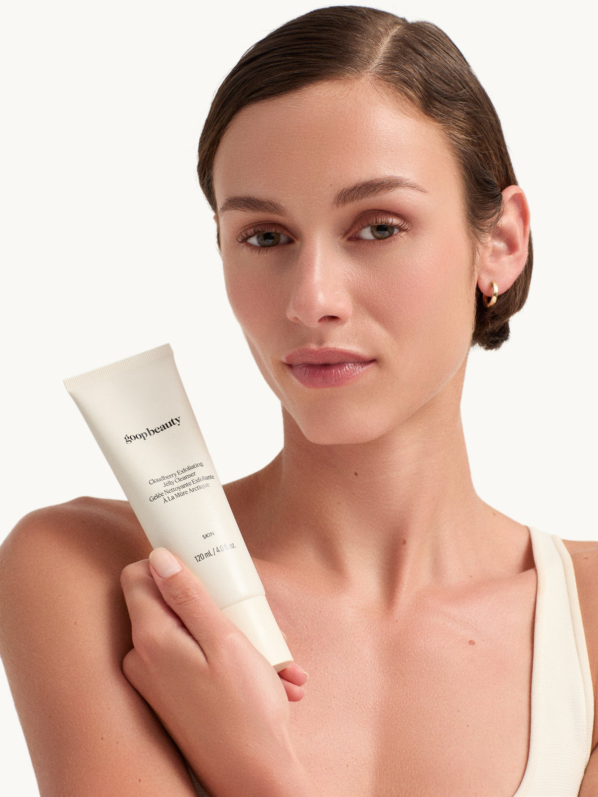 model holding goop beauty Cloudberry Exfoliating Jelly Cleanser