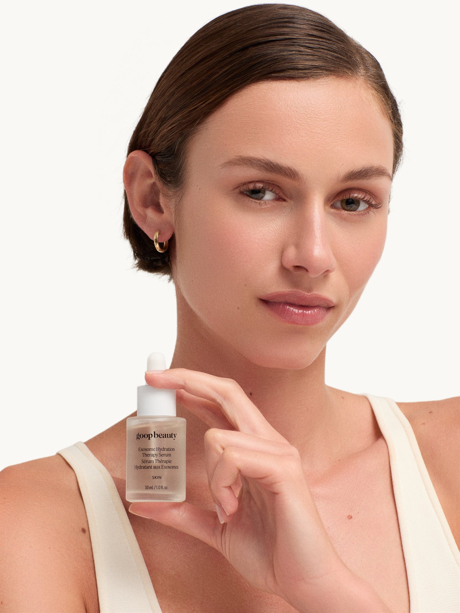 Model holding goop beauty Exosome Hydration Therapy Serum