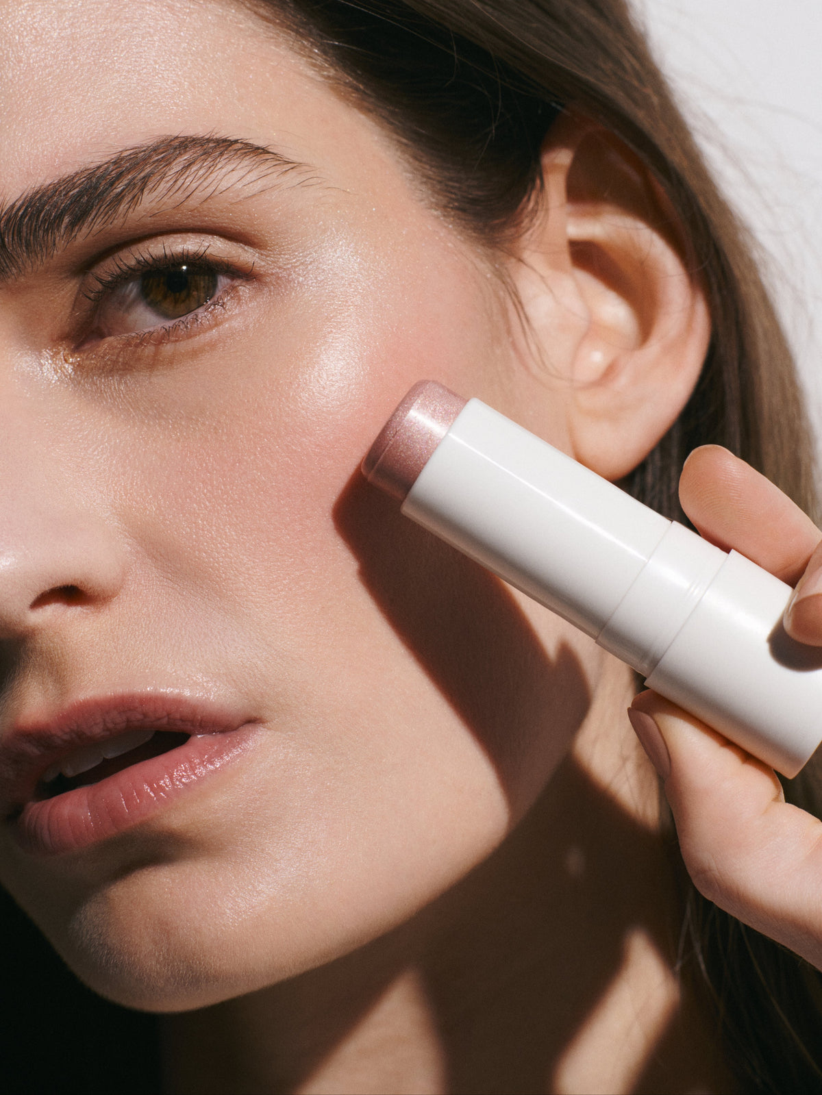 goop beauty Glow Skin Highlighter Stick in Petal applied to cheekbones