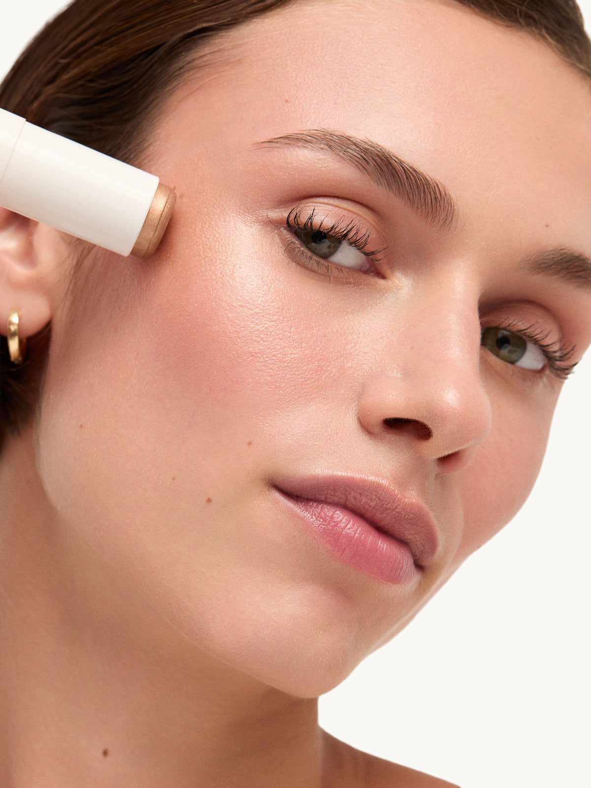 GOOP BEAUTY Glow Skin Highlighter Stick in Sunny applied to the cheek