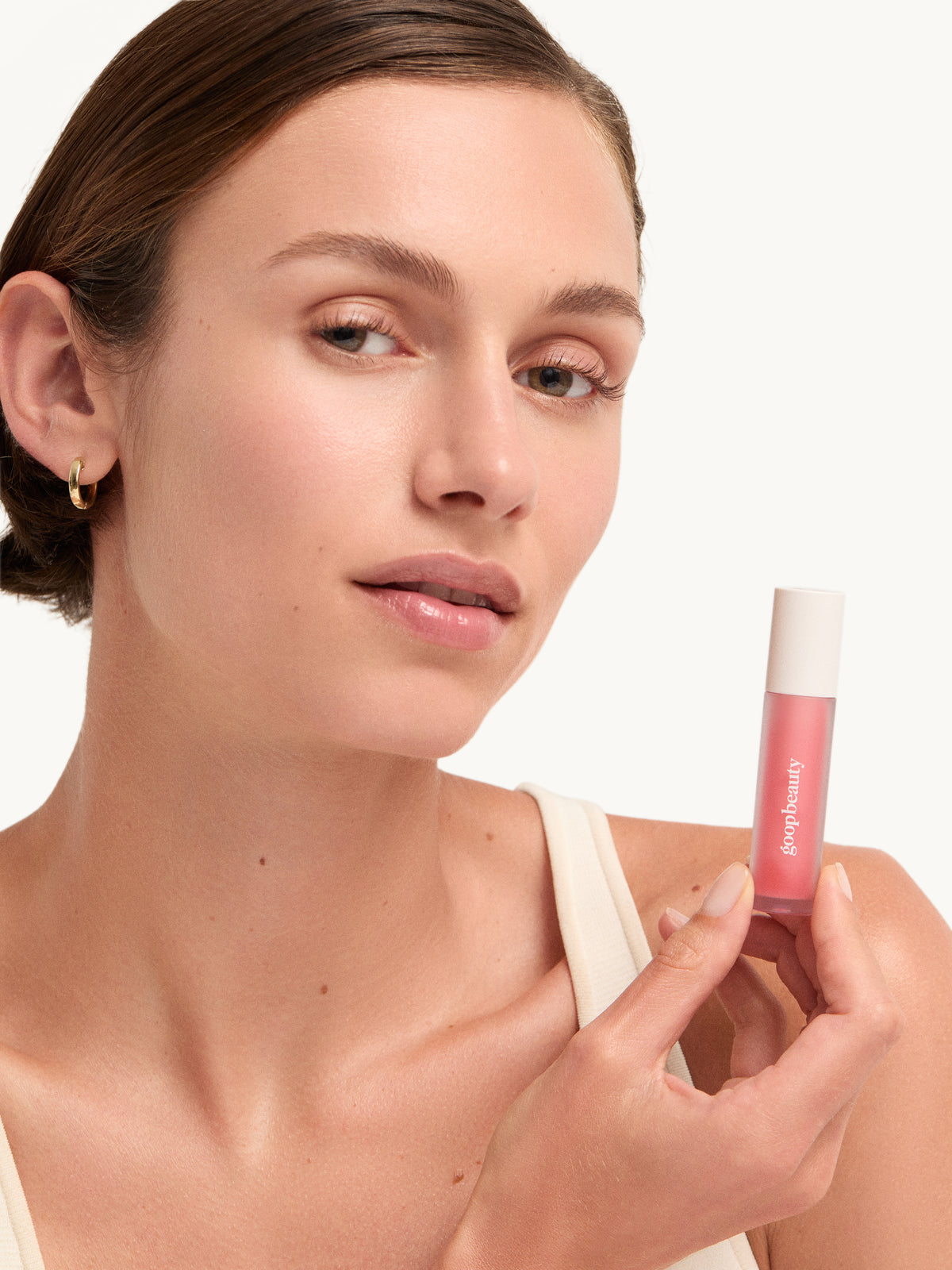 Model holding goop beauty Hydra-Barrier Gel Gloss in Glaze