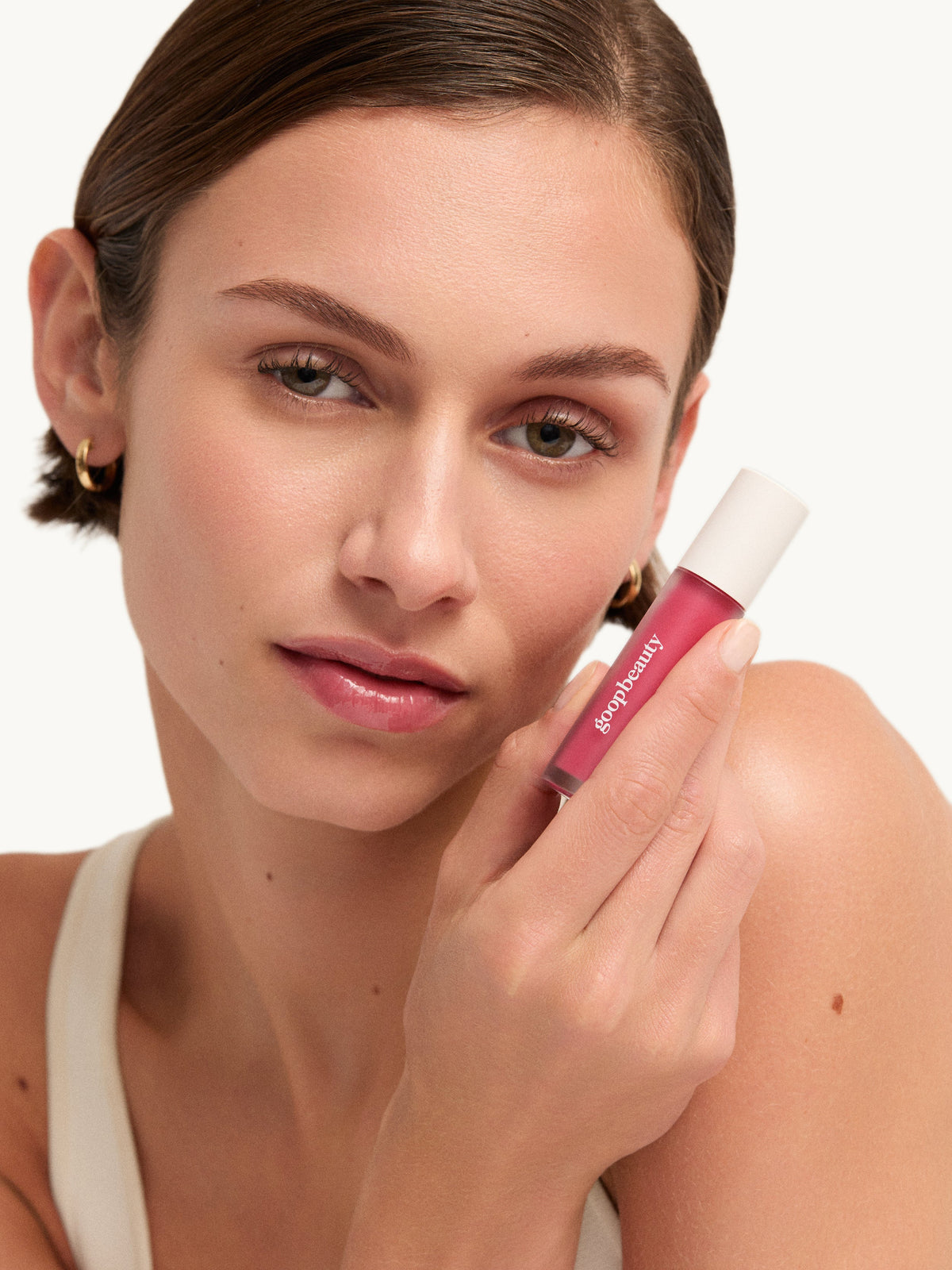 Model holding goop beauty Hydra-Barrier Gel Gloss in Tulip