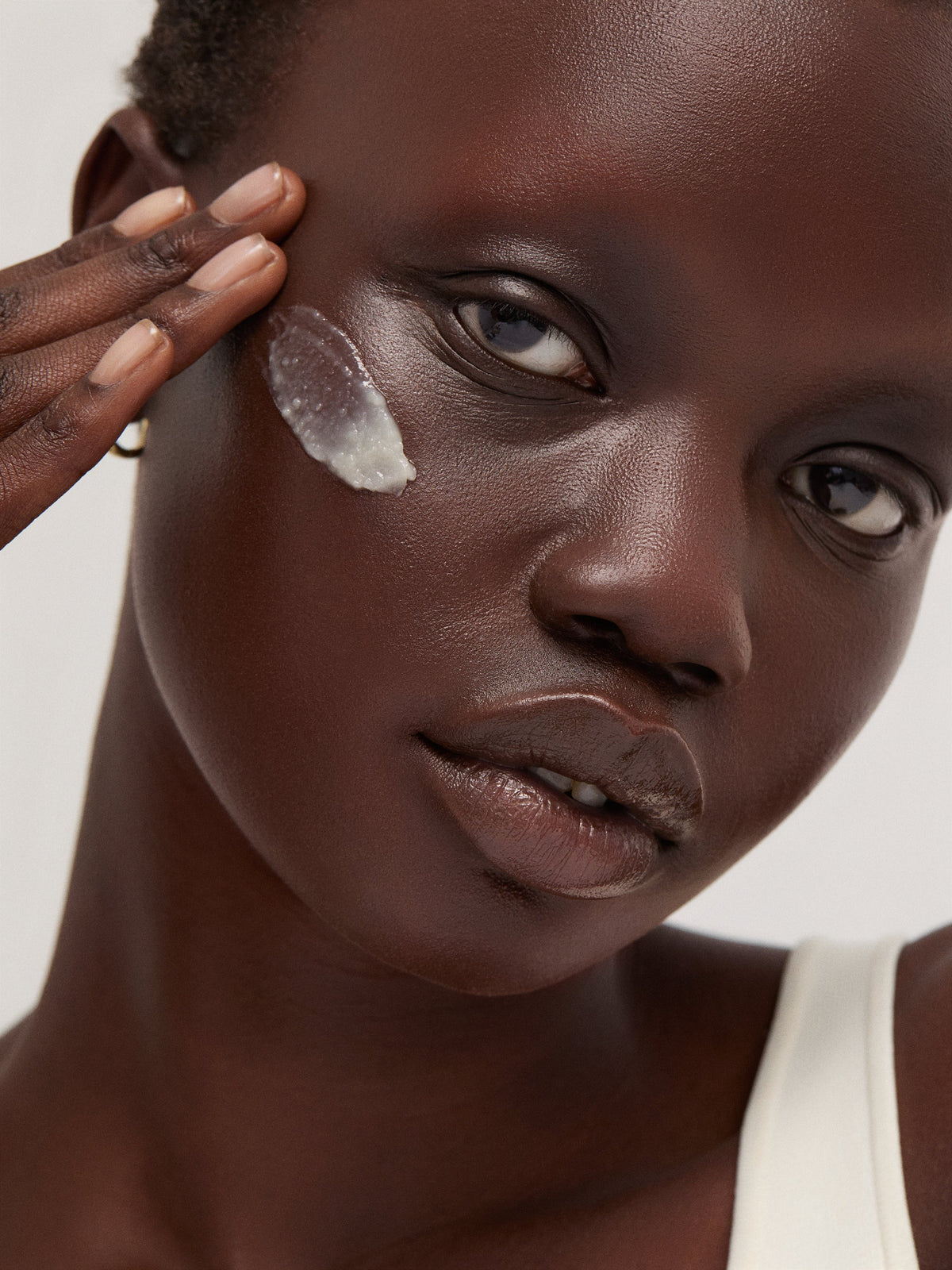 goop beauty Luminous Cleansing Balm held by model