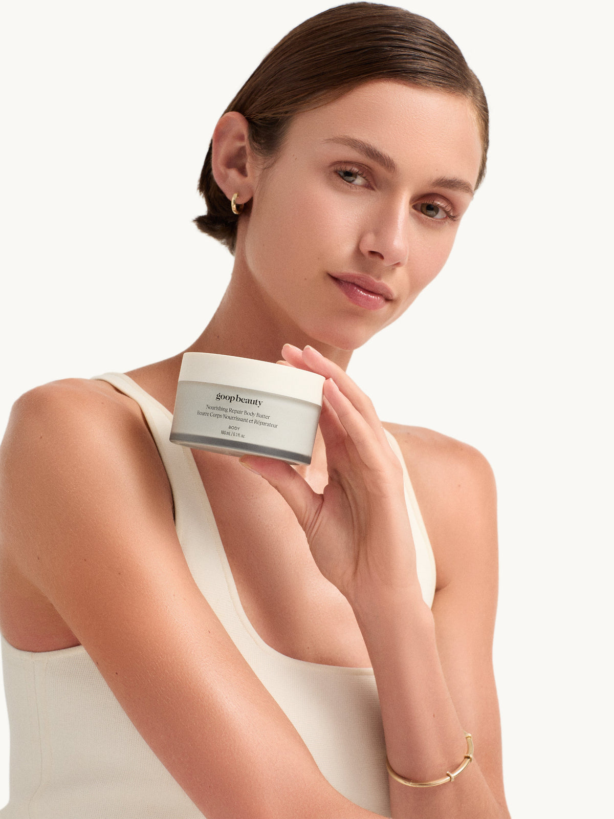 Model holding goop beauty Nourishing Repair Body Butter