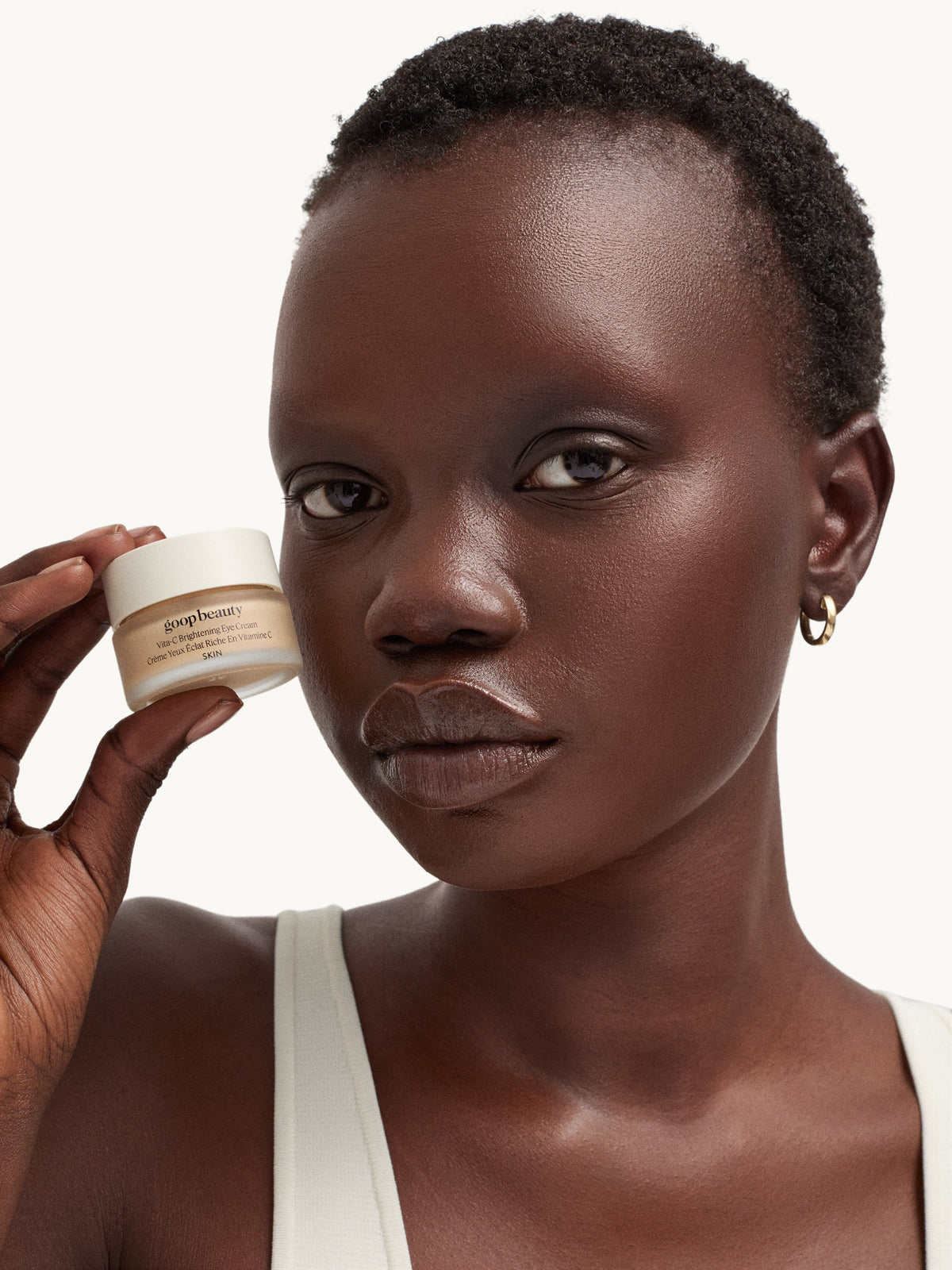 Model holding goop Vita-C Brightening Eye Cream