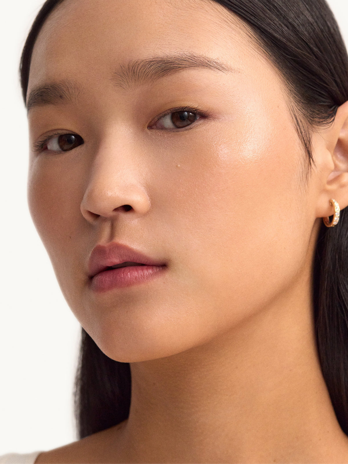 Model with glowing skin using goop Youth-Boost NAD+ Peptide Rich Cream