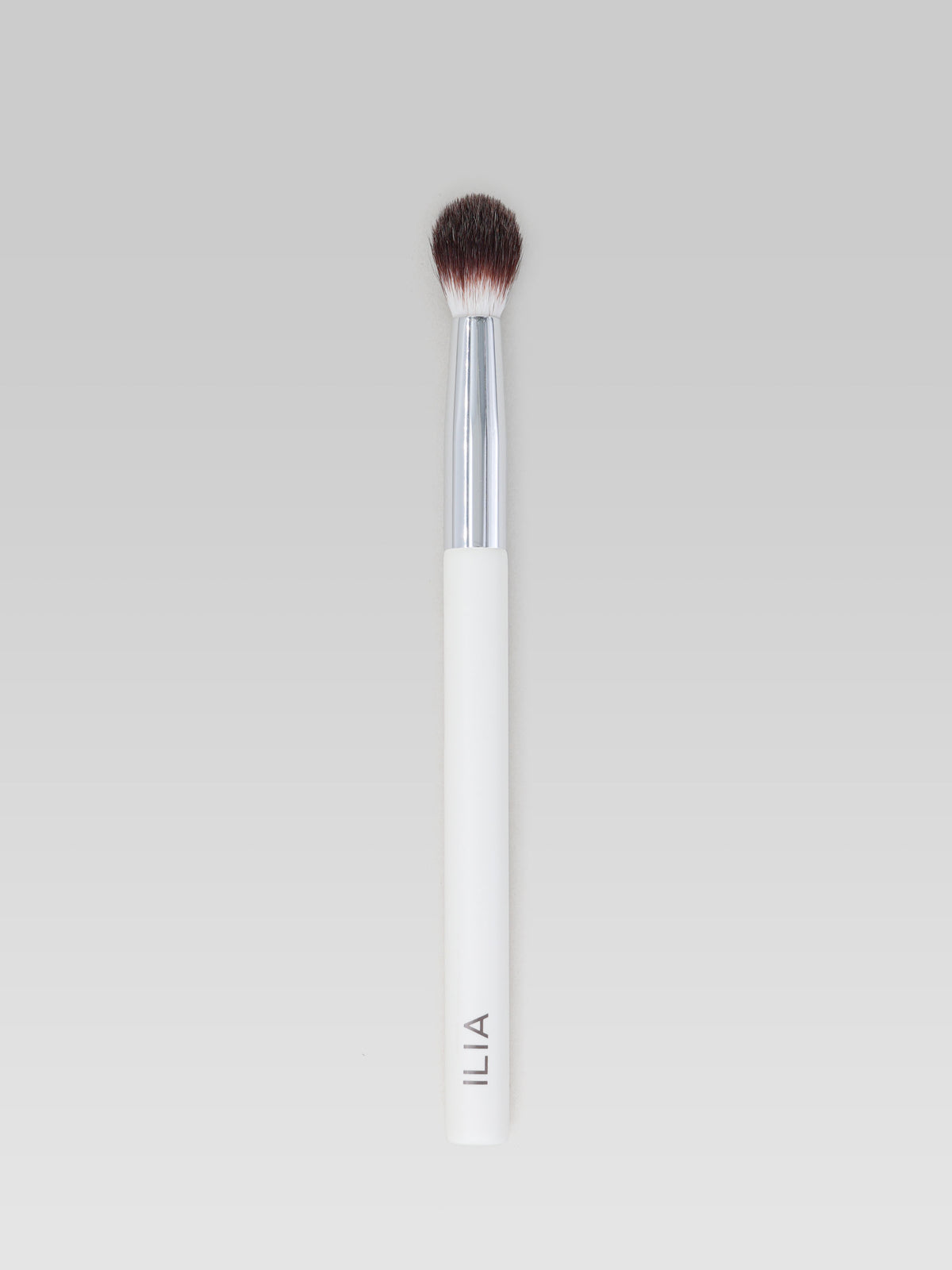 ILIA BEAUTY Blending Brush with soft, tapered bristles, a silver ferrule and a white handle for blending eyeshadow seamlessly.