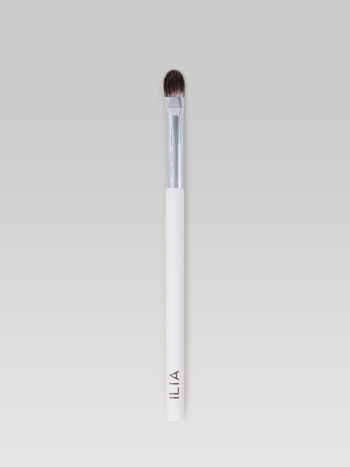 ILIA BEAUTY Shadow Brush with a small, rounded brush head, soft bristles, a silver ferrule and a white handle for precise eyeshadow application.