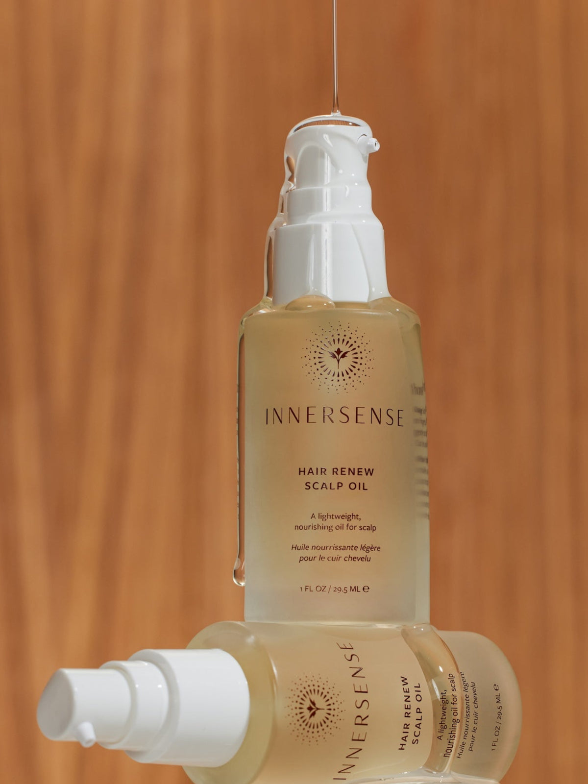 INNERSENSE Hair Renew Scalp Oil bottles in a warm lifestyle setting
